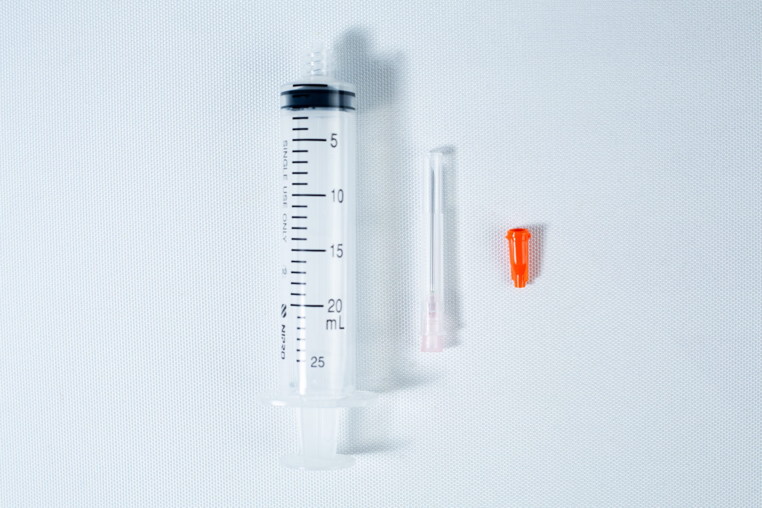 Syringes Luer lock with Hypodermic Needle and syringe Cap set 3 A 25 mL syringe, a needle, and an orange cap on a white background.