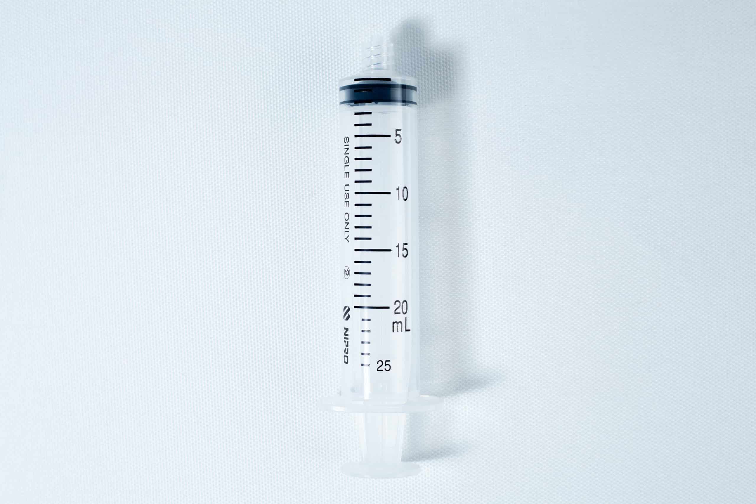 Syringes Luer lock with Hypodermic Needle and syringe Cap set 5 A clear, empty plastic syringe with black measurement markings up to 25 mL on a white background.