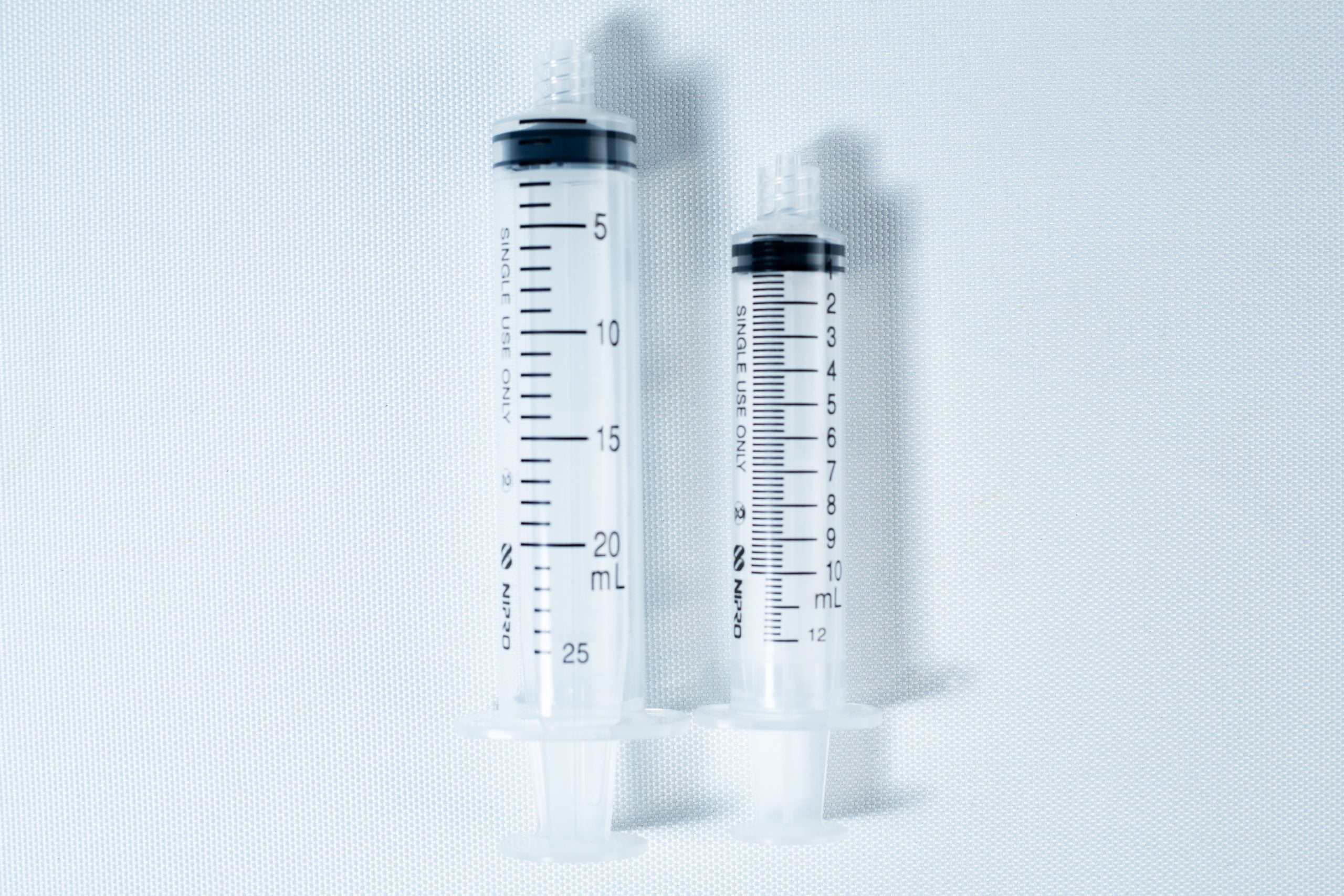 Syringes Luer lock with Hypodermic Needle and syringe Cap set 1 Two clear plastic syringes, one large and one small, placed side by side on a white background.