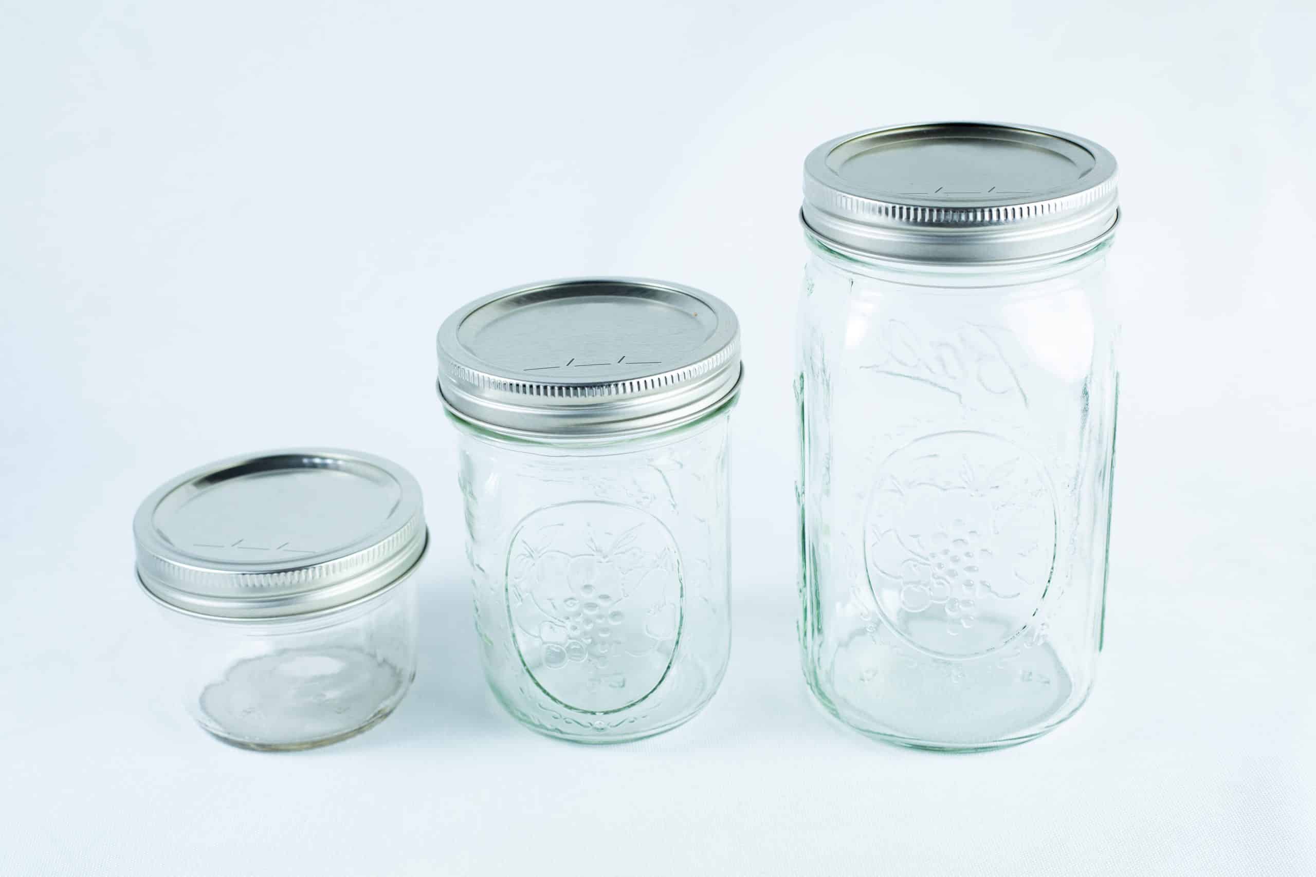 Metal lid and band set for wide mouth mason jar | 86mm 5 Three empty wide-mouthed glass Mason jars, each featuring an 86mm metal lid and band set, are arranged on a white background.
