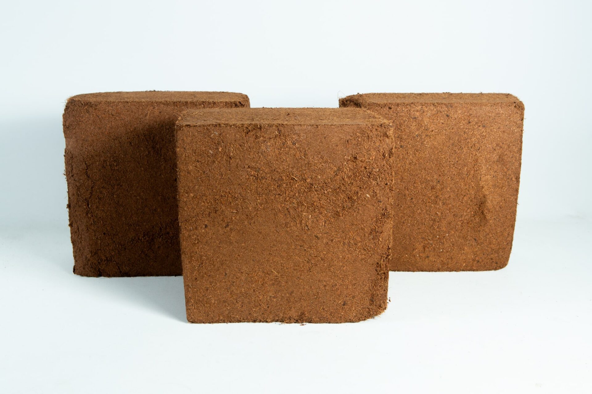 Coco coir block 4.5-5 Kg, 60L, Washed of salts Buffered RHP grade 2 Three brown, square Coco Coir Block 5 kg (60L), Washed of Salts, Buffered RHP grade blocks are arranged against a plain white background.