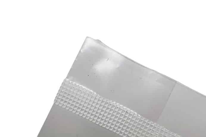 CVG Substrate | CVG Monotub Mushroom Bulk Substrate | Coco Verm Gypsum 4 Close-up of the corner of a clear plastic bag with a textured sealing strip on a white background.