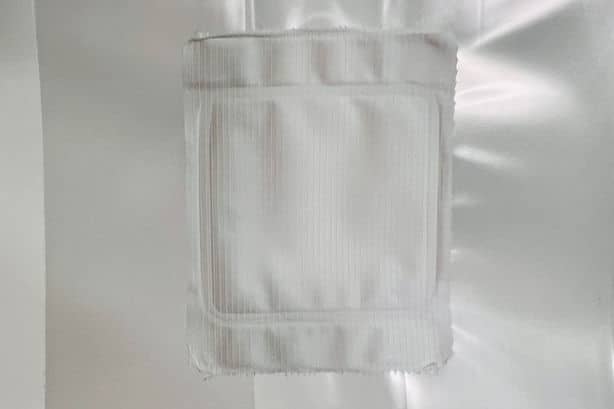 CVG Substrate | CVG Monotub Mushroom Bulk Substrate | Coco Verm Gypsum 3 A white, square gauze pad is attached to a white, shiny surface.