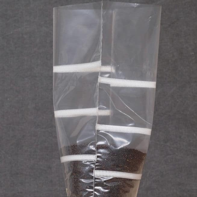 Grow bags Mushroom Sac O2 6 Grow bags Mushroom Sack O2, clear plastic with white cable ties, partially filled with small dark seeds, shown against a grey background.