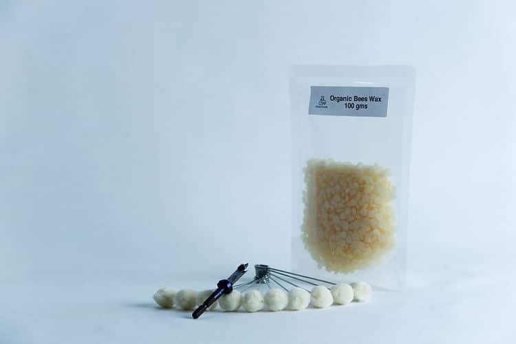 Mushroom Log Kit | Mushroom Inoculation Kit (Log Dowel) 1 A packet of organic beeswax and a tool with white beads, ideal for your Mushroom Log Kit | Mushroom Inoculation Kit (Log Dowel), displayed on a clean white background.