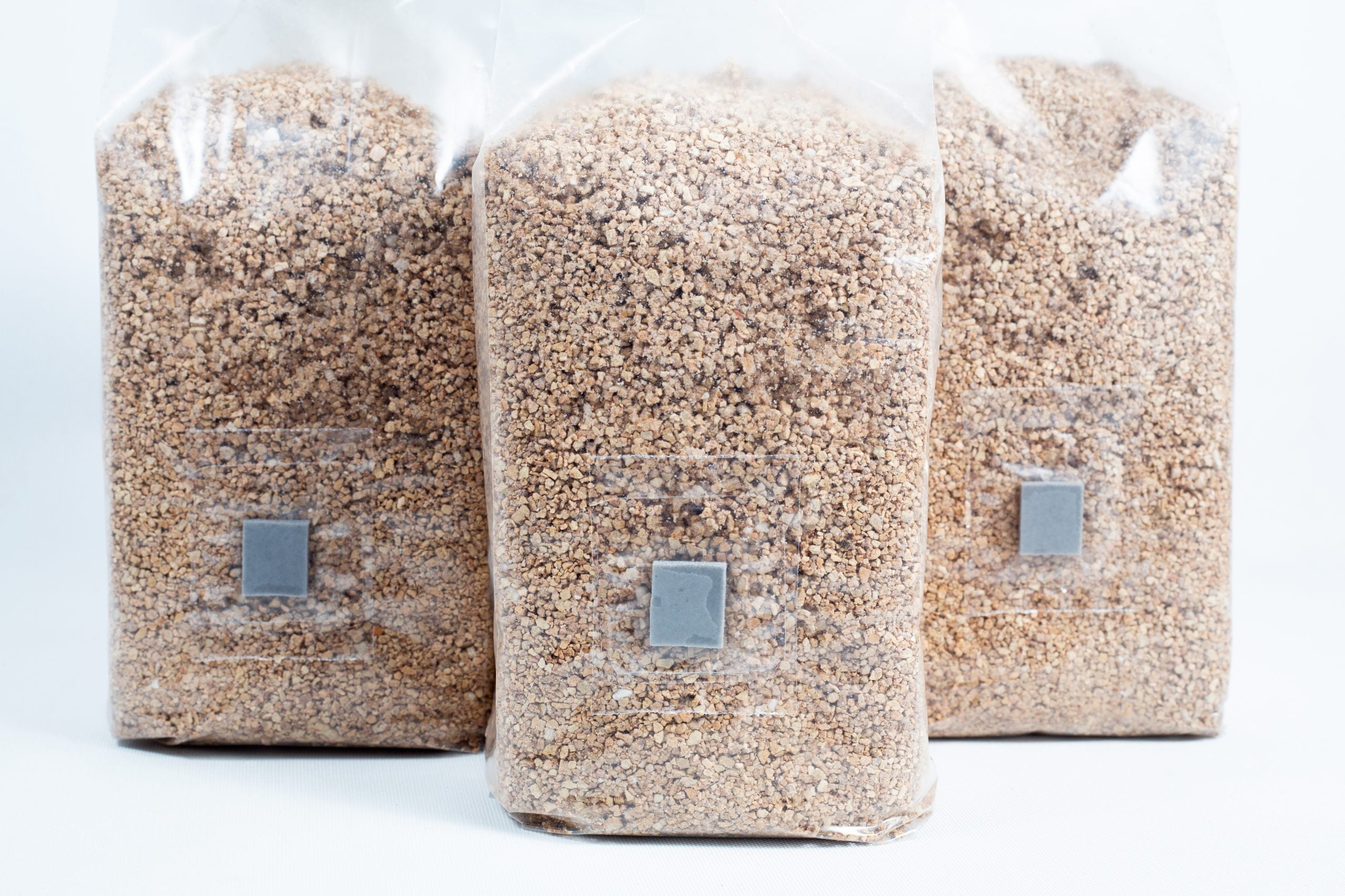 3X 1kg Organic Brown Rice Flour (BRF) & Vermiculite bags PF Tek 3 Three 1kg bags of organic brown rice flour (BRF) and vermiculite for PF Tek mushroom cultivation stand upright on a white background.