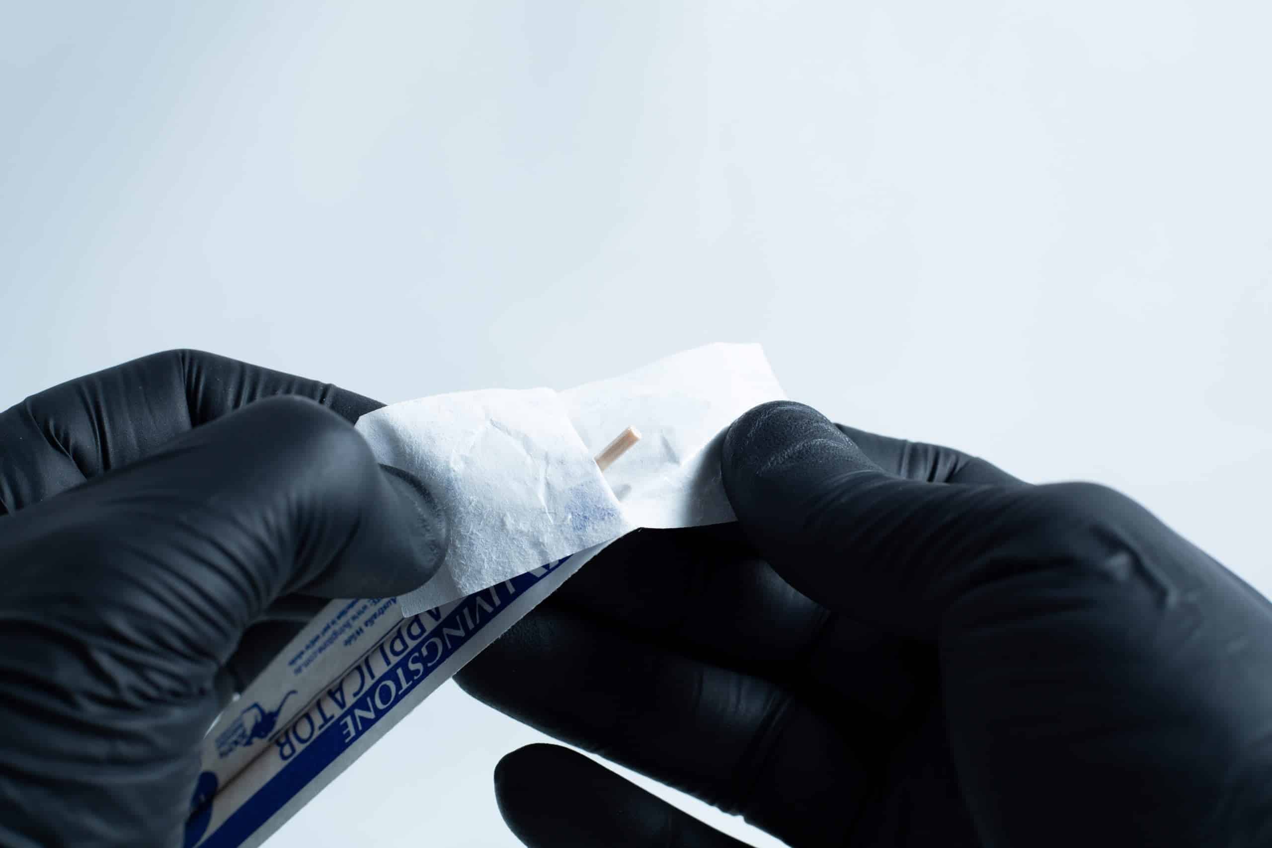 Agar petri dish MEA School Science Fun Project Kit 11 Gloved hands open an antiseptic wipe packet against a plain background, preparing the agar Petri dish MEA School Science Fun Project Kit for a school science activity.