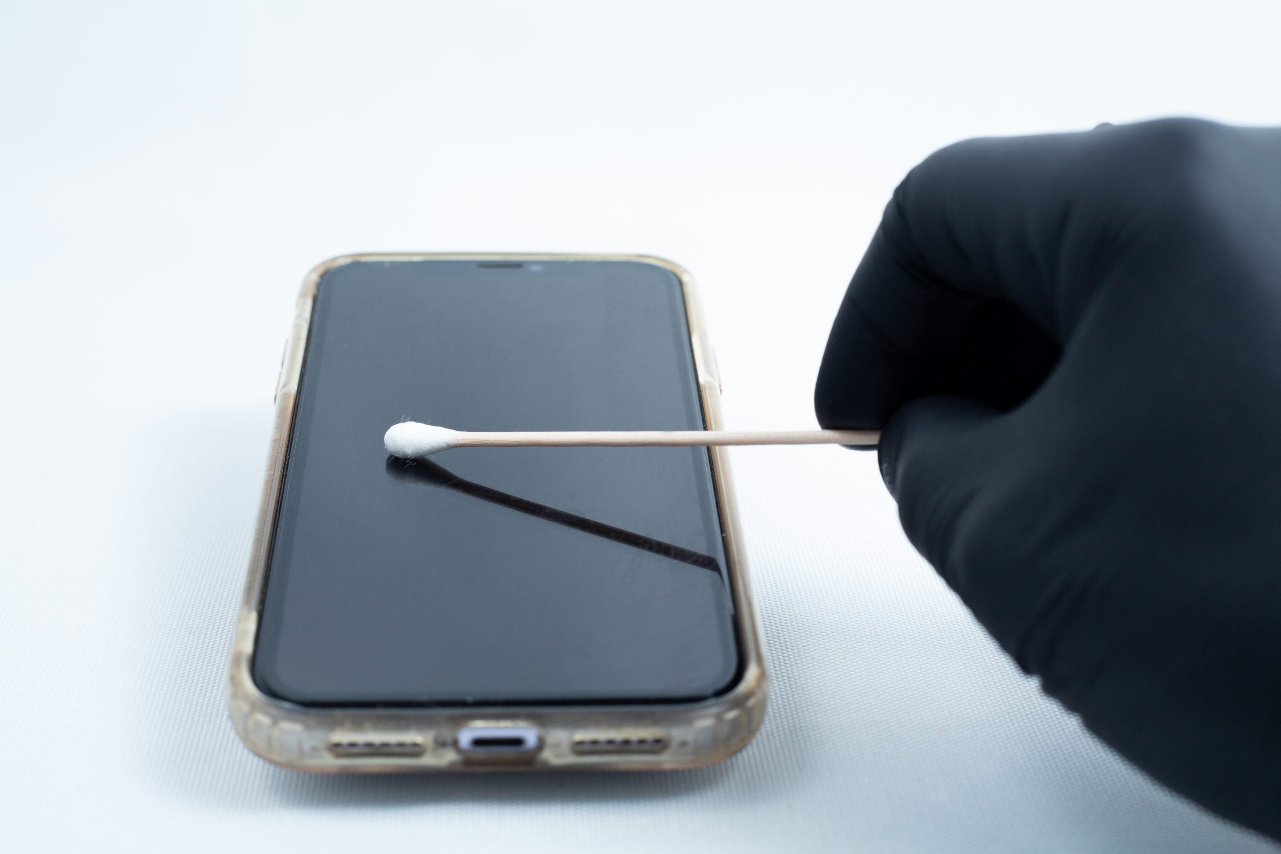 Agar petri dish MEA School Science Fun Project Kit 4 A gloved hand cleans a smartphone screen with a cotton bud, resembling the precise care used in school science projects with the Agar petri dish MEA School Science Fun Project Kit.