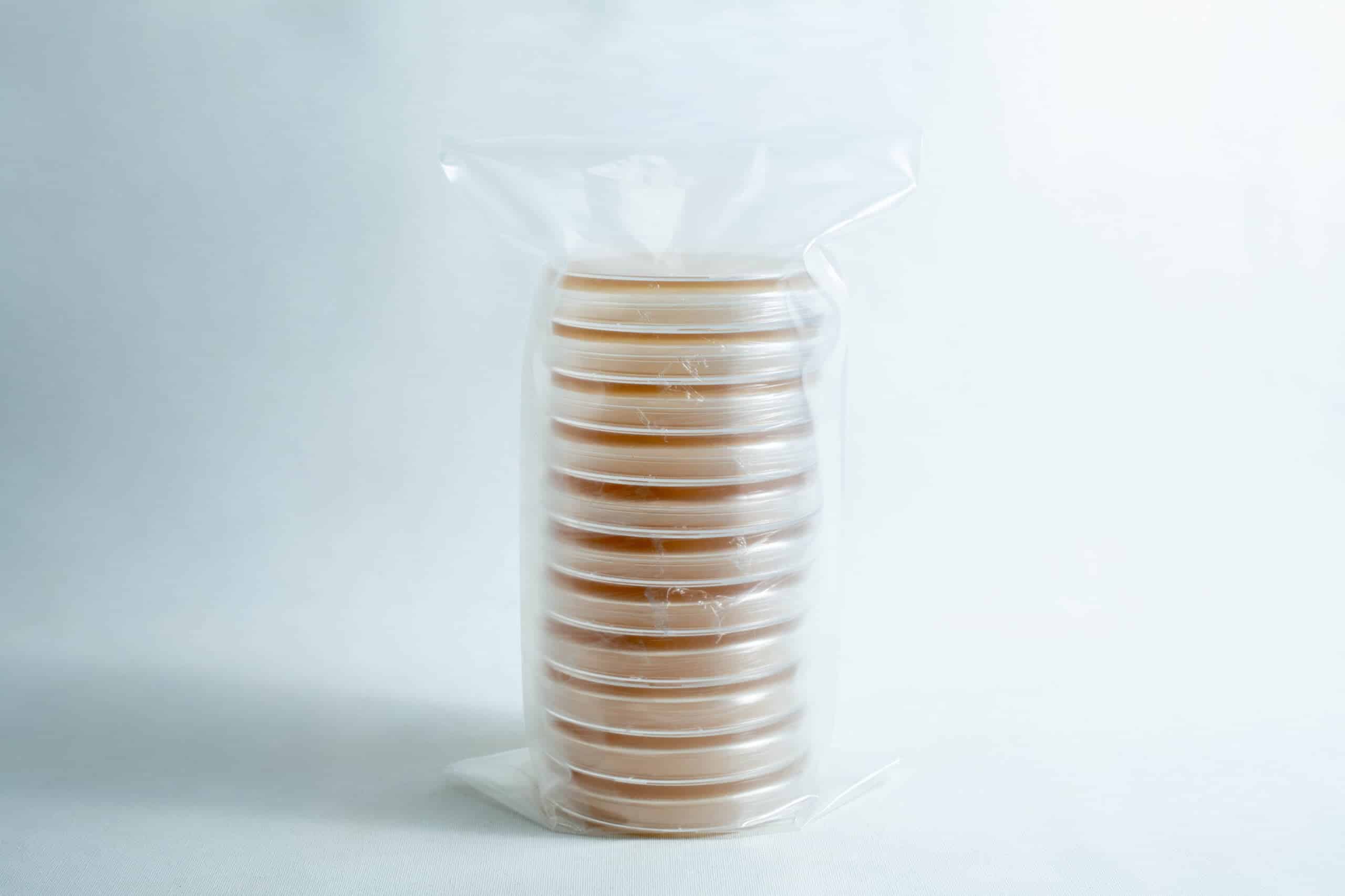 Pre poured MEAG Agar Plates (Antibacterial) 90mm 3 A stack of sealed Pre-poured MEAG Agar Plates (Antibacterial) 90mm, filled with agar and wrapped in clear plastic, displayed on a white background.