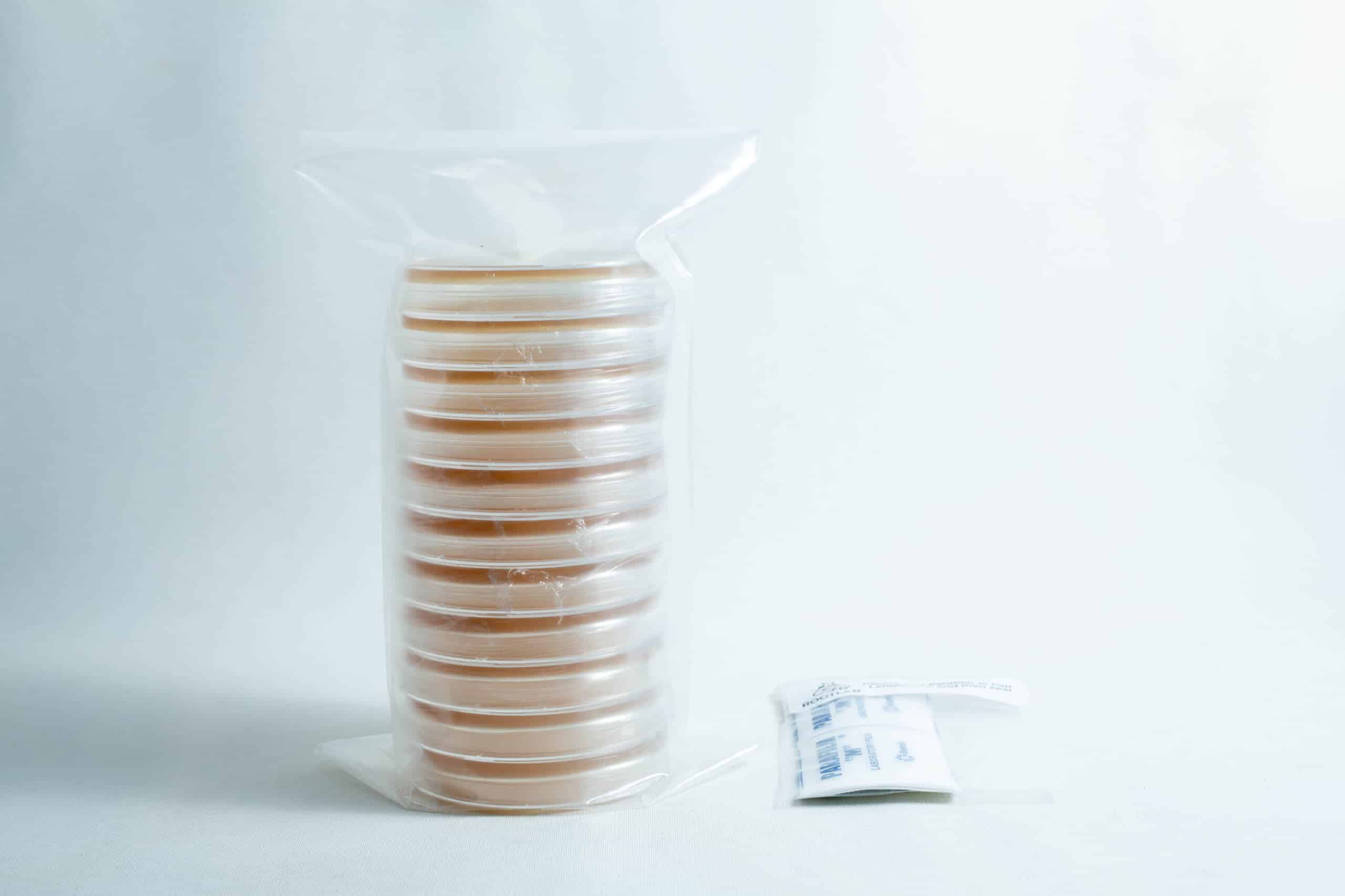 Pre poured MEAG Agar Plates (Antibacterial) 90mm 1 A stack of pre-poured MEAG agar plates (antibacterial) 90mm, sealed in plastic, sits next to a small packet on a white surface.