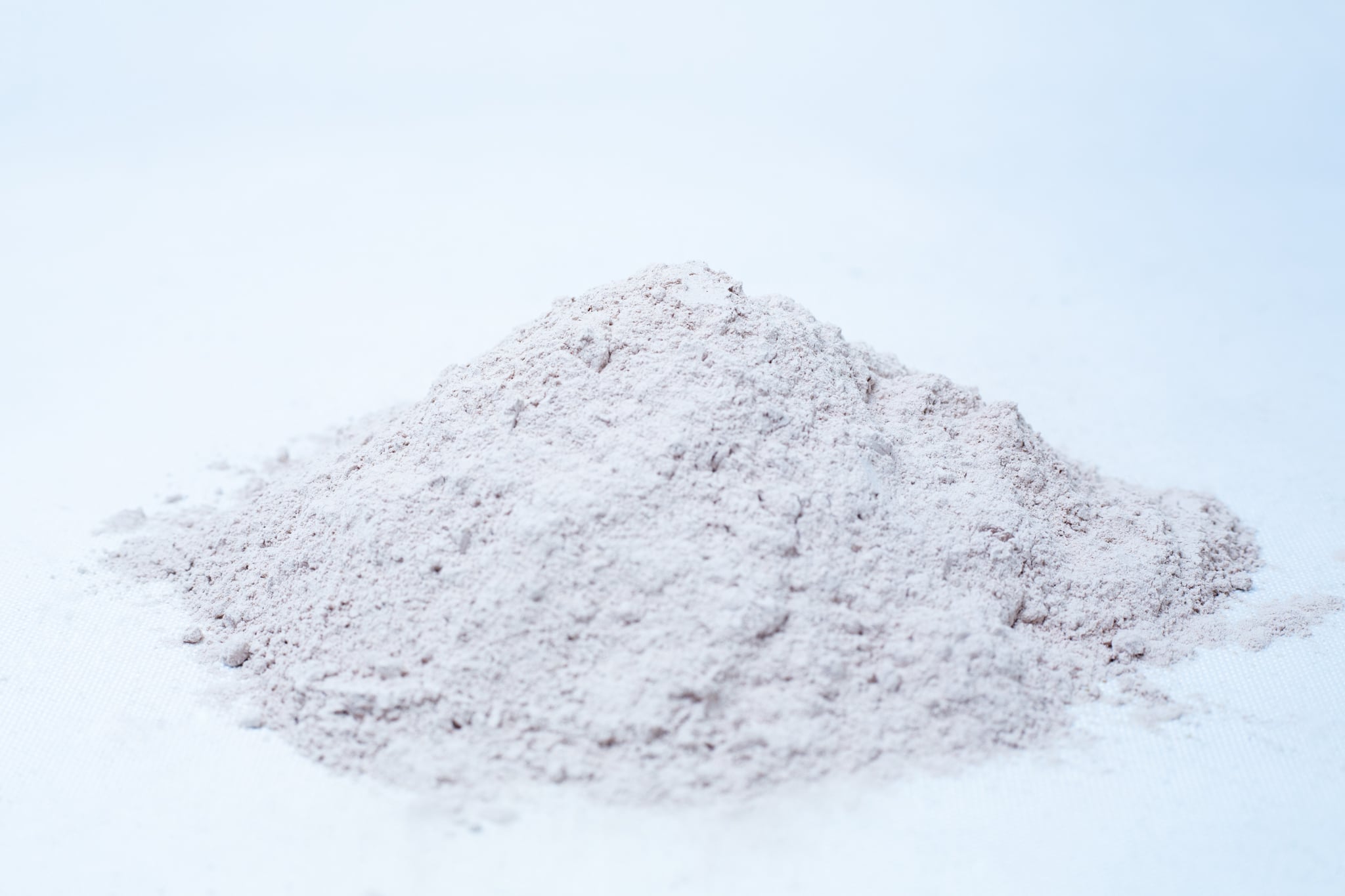 Azomite- Supplement for mushroom growing 1 A small mound of Liquid Culture Pre-mix | DLME | Now Extra Clear, a fine, light-coloured powder perfect for mixing dextrose and light malt extract, sits on a white surface against a plain background.