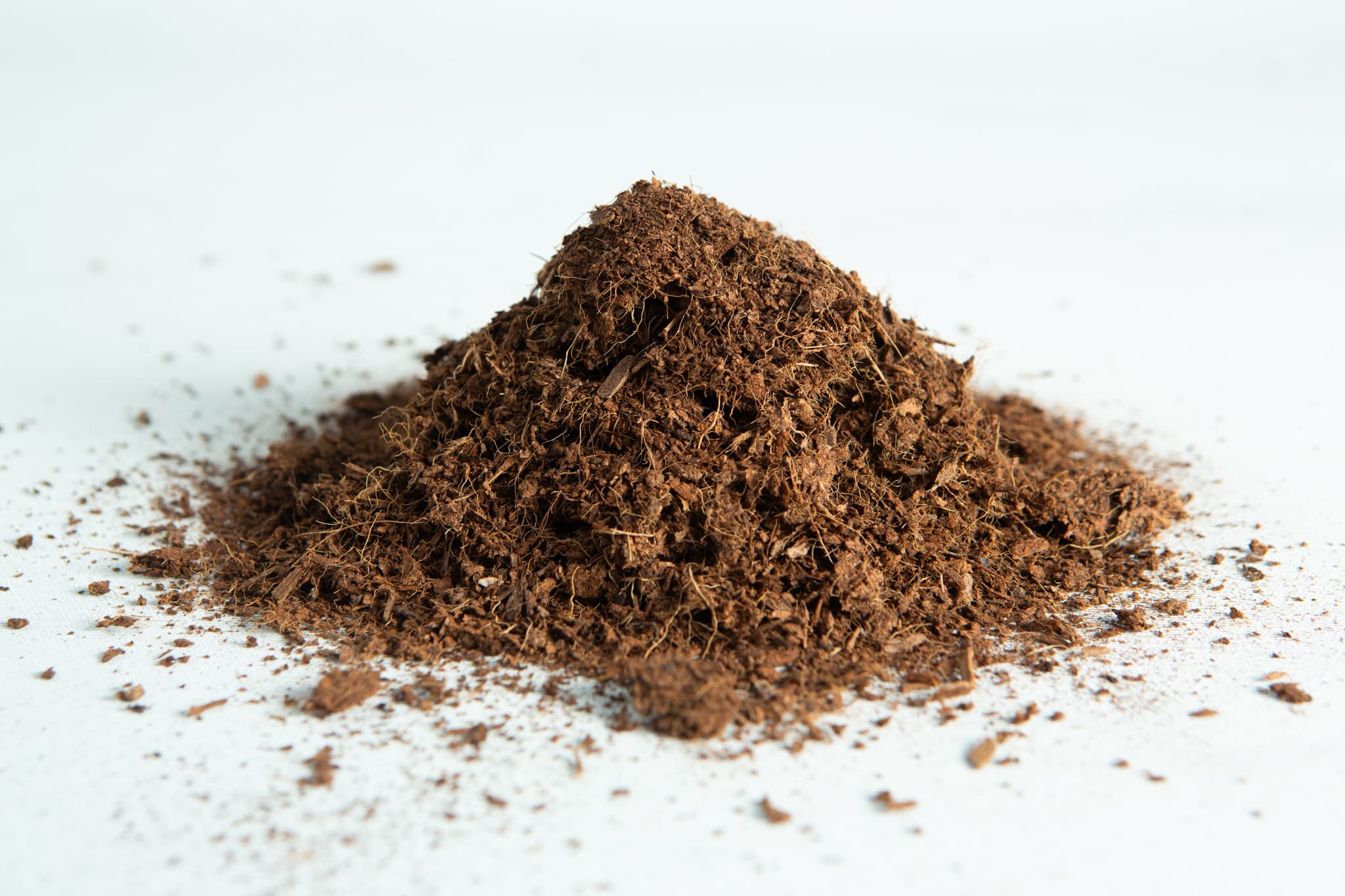 Coco coir block 4.5-5 Kg, 60L, Washed of salts Buffered RHP grade 3 A small pile of coco coir block 5 kg, 60L, washed of salts buffered RHP grade on a white surface.