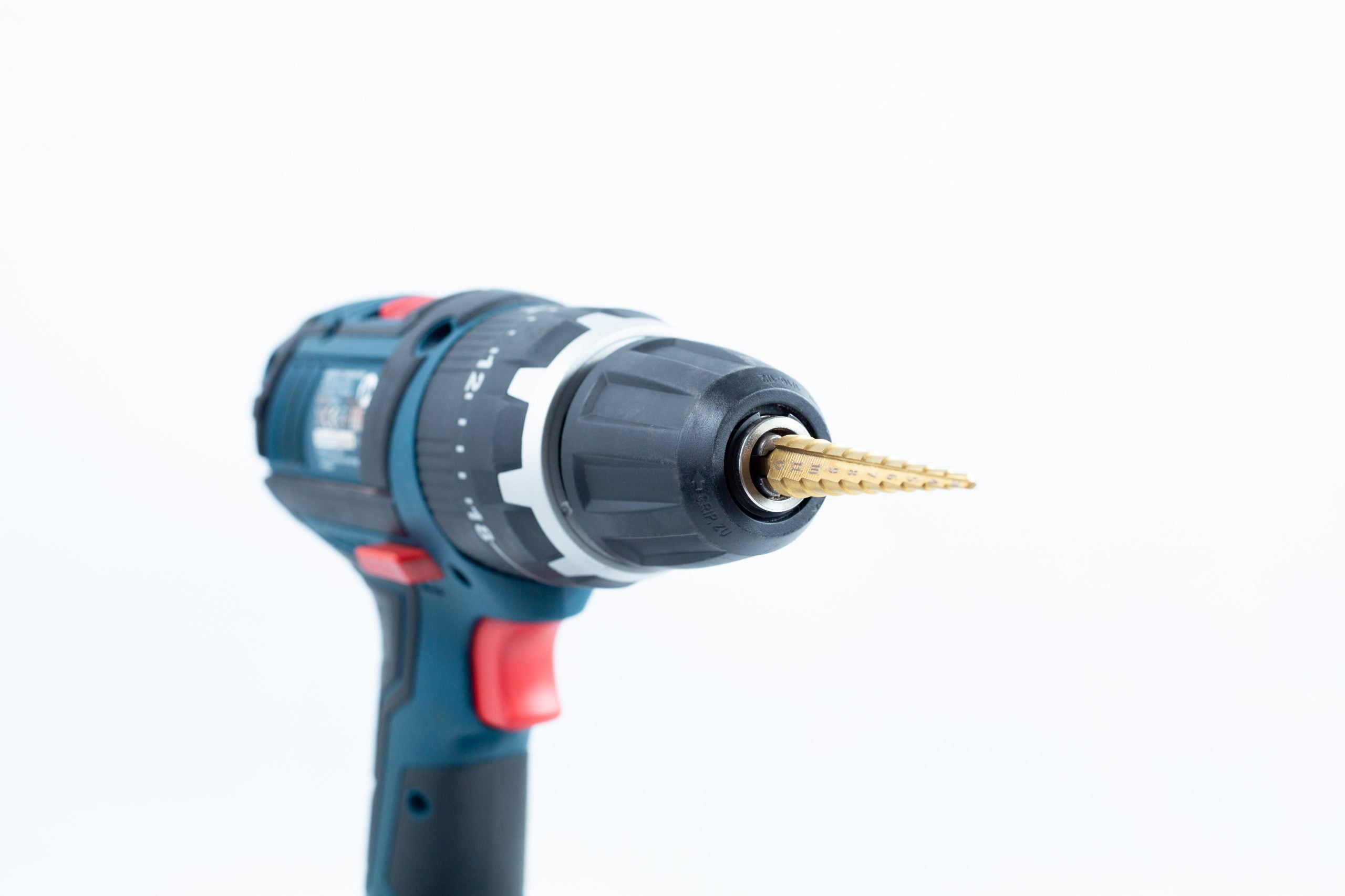 Drill Bit for holes size 3mm-12mm Titanium Coated 4 A Drill Bit for holes size 3mm-12mm Titanium Coated is attached to a cordless power drill, displayed against a white background.