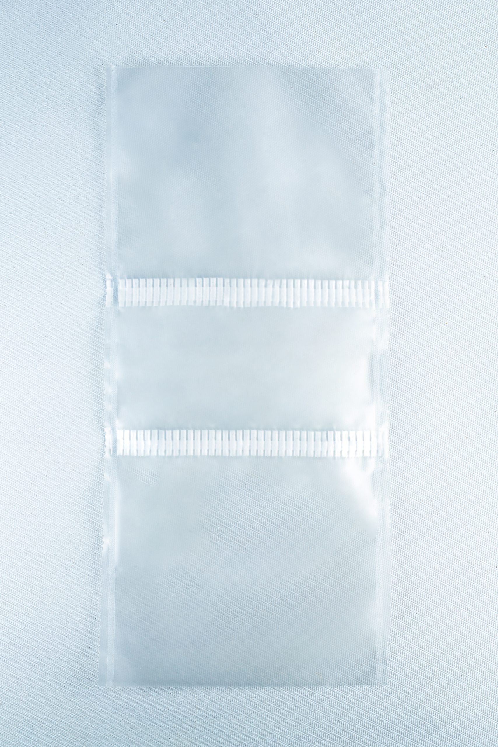 Grow bags Mushroom Sac O2 1 Three empty Unicorn Mushroom Grow Bags for spawn and substrate, made of transparent plastic with horizontal seals, are laid flat on a white background.