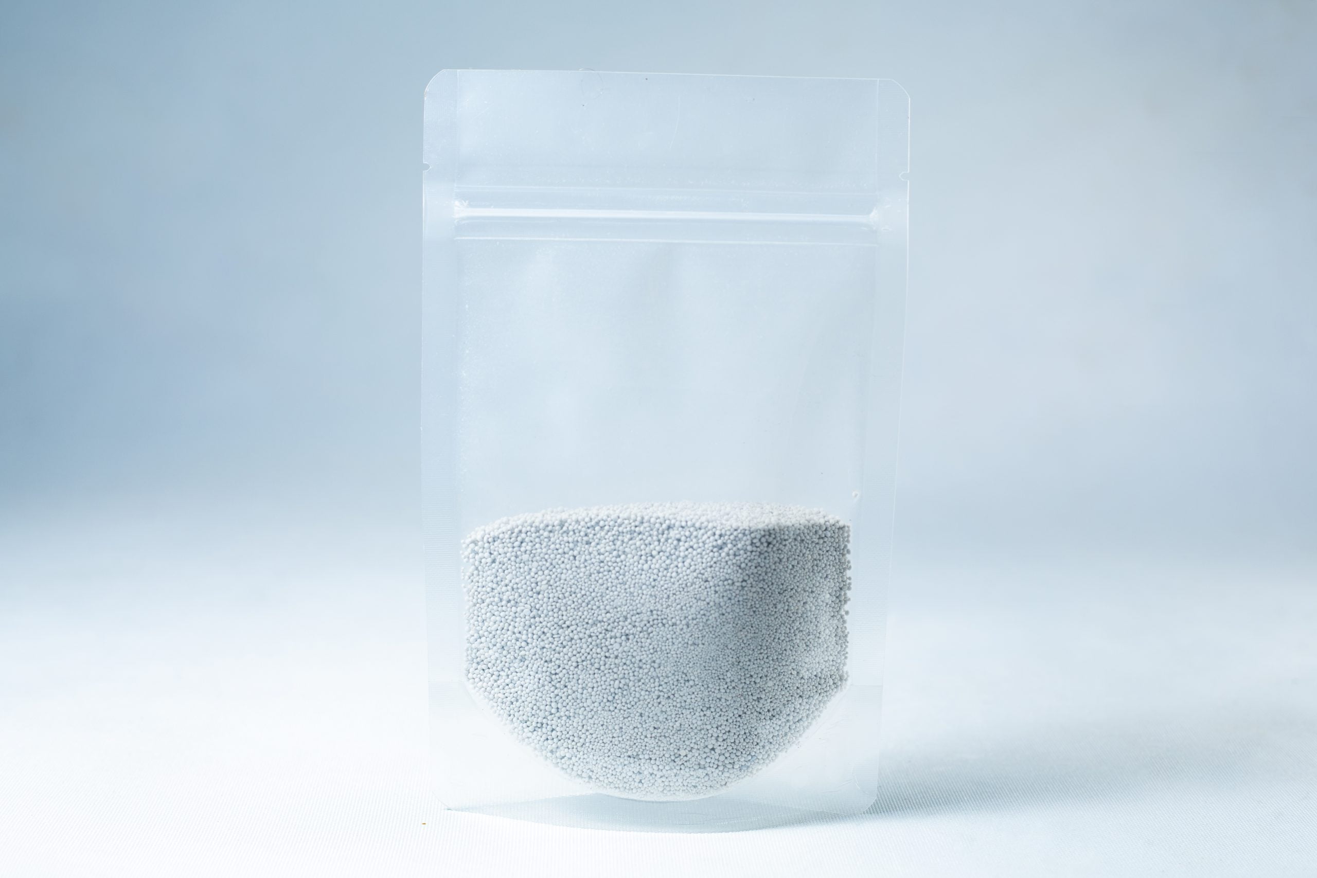 Natural Gypsum coarse grade mushroom supplement grain and substrate 2 A clear resealable plastic pouch filled halfway with Natural Gypsum coarse grade mushroom supplement grain and substrate, featuring small white gypsum granules, shown on a light background.