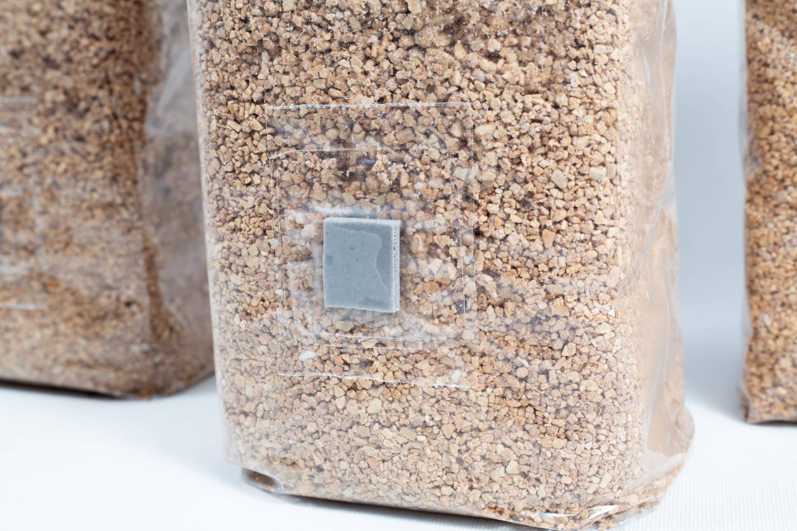 3X 1kg Organic Brown Rice Flour (BRF) & Vermiculite bags PF Tek 4 A clear bag of brown grains with a grey patch, ideal for mushroom substrates—perfect for PF Tek using 3×1kg Organic Brown Rice Flour (BRF) & Vermiculite bags.