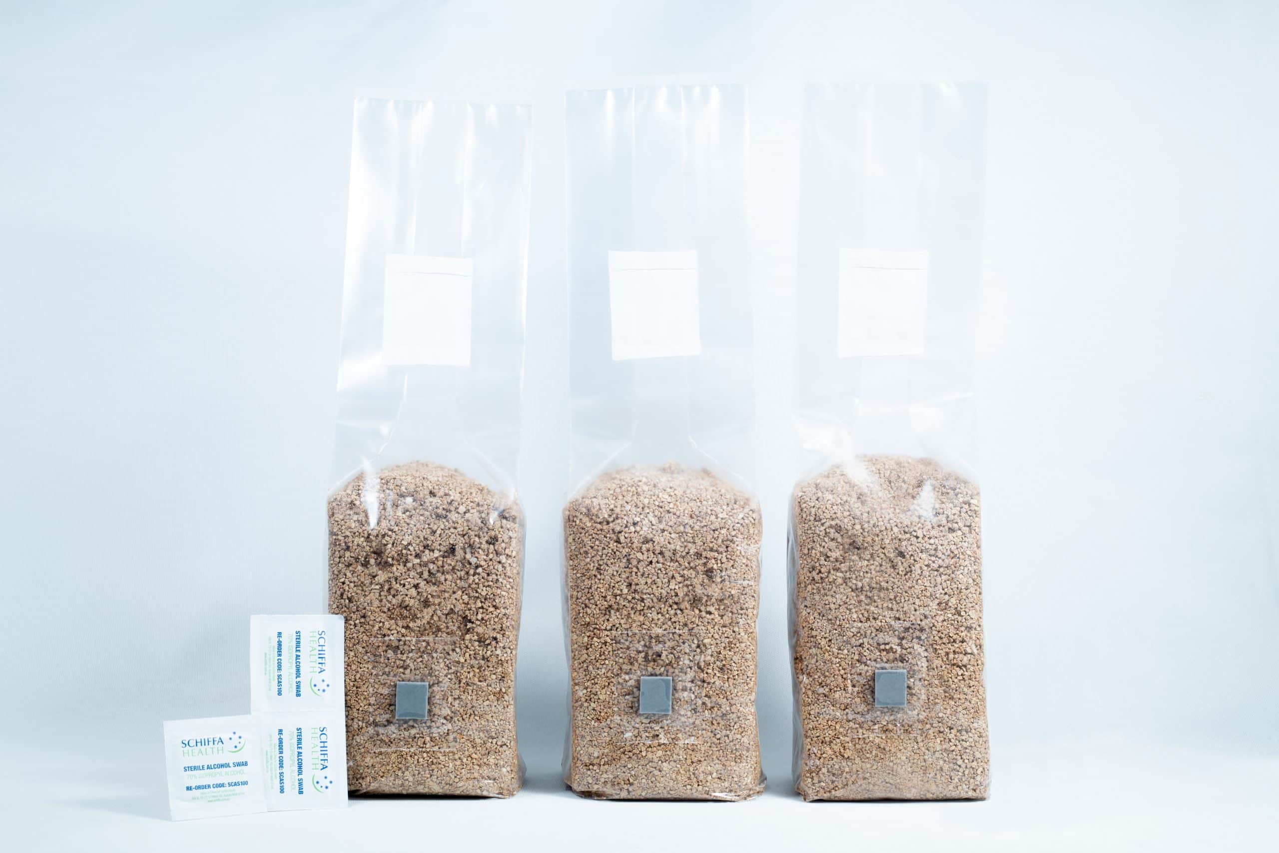 3X 1kg Organic Brown Rice Flour (BRF) & Vermiculite bags PF Tek 1 Three 1kg Organic Brown Rice Flour (BRF) & Vermiculite bags for PF Tek sit beside two silica gel sachets on a white background.