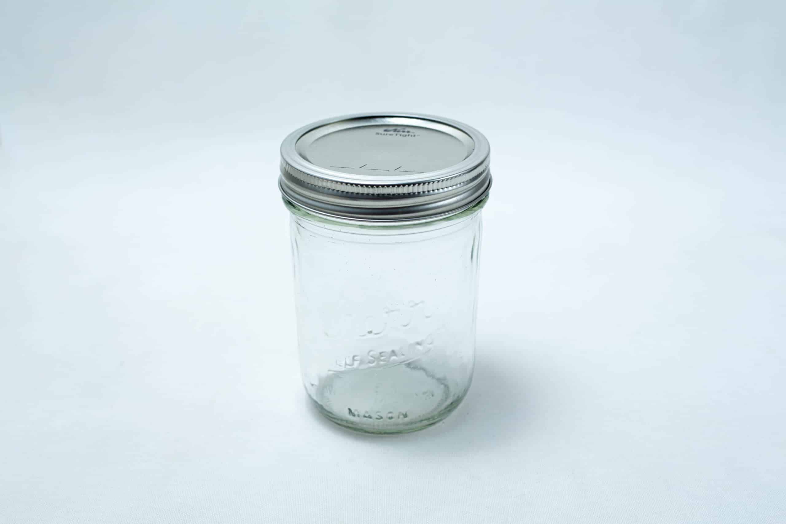 Kerr wide mouth Mason jar glass pint size 473ml with lids and bands x 12 2 A set of 12 Kerr wide mouth Mason jars, pint size (473ml), with silver lids and bands is displayed on a plain white background.