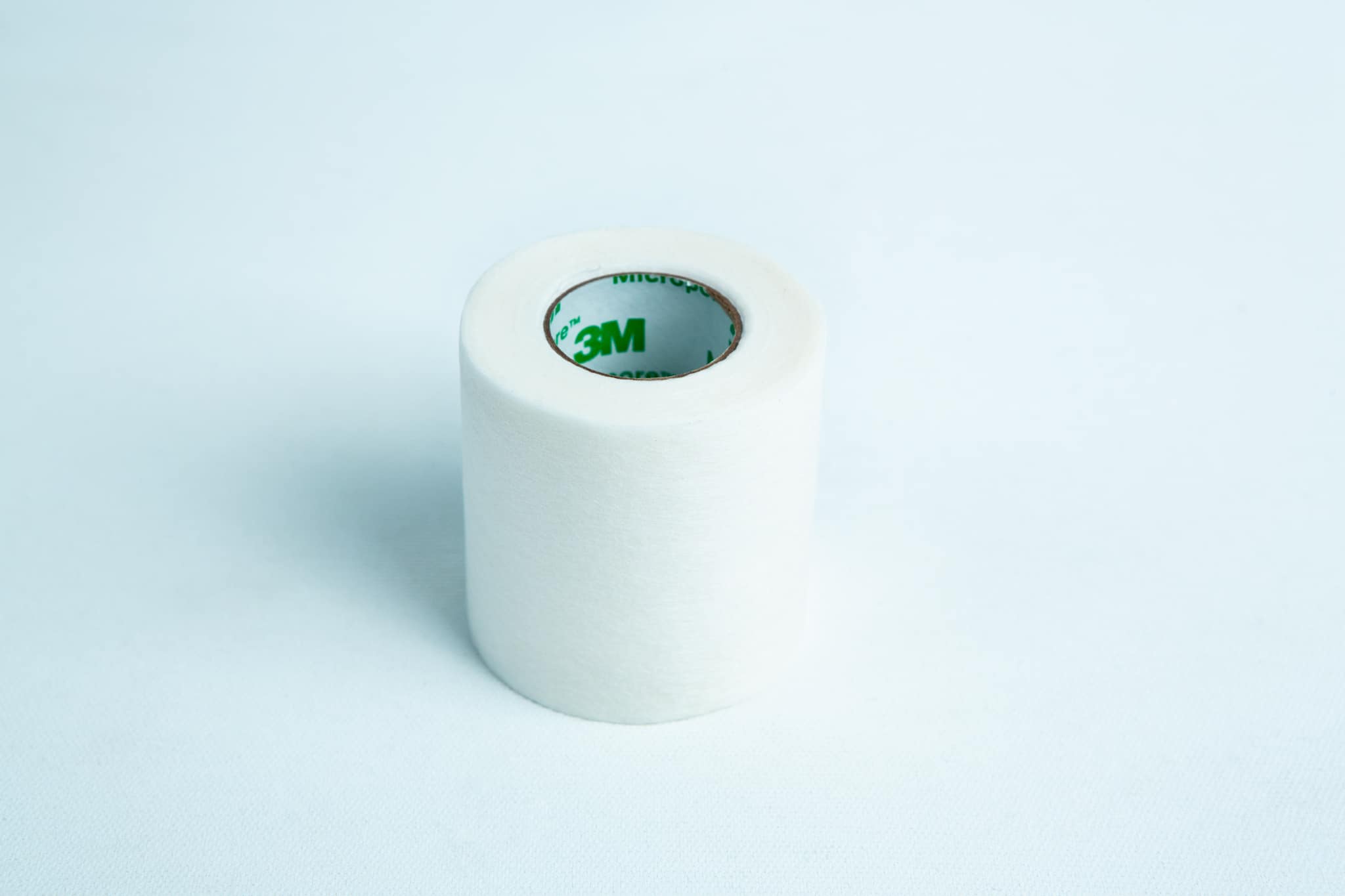 Monotub mushroom growing kit- Max Yield Bins 14 A roll of Micropore tape Mycology autoclavable breathable rests on a light blue background, ready for gentle and secure medical use.