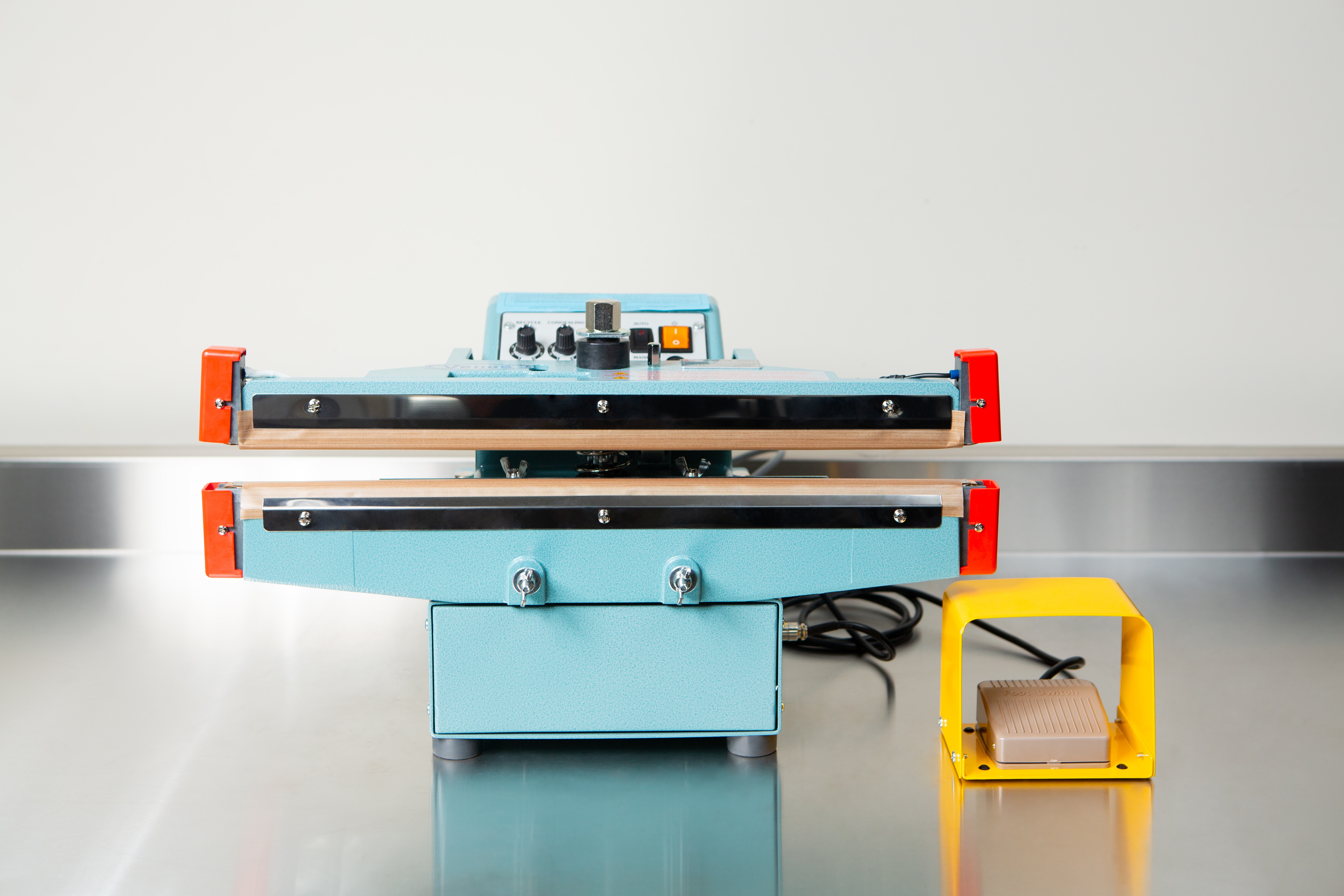 Heat Sealer 450mm with 10mm Seal | Benchtop Model 1 A Heat Sealer 450mm with 10mm Seal | Benchtop Model, featuring control knobs and a yellow foot pedal, sits on a metal counter, designed for reliable industrial sealing.