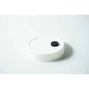 The Mycology premade Wide Mouth Mason Jar Lid is white with an injection port and air filter, featuring a textured surface—perfect as an autoclavable lid for liquid culture.