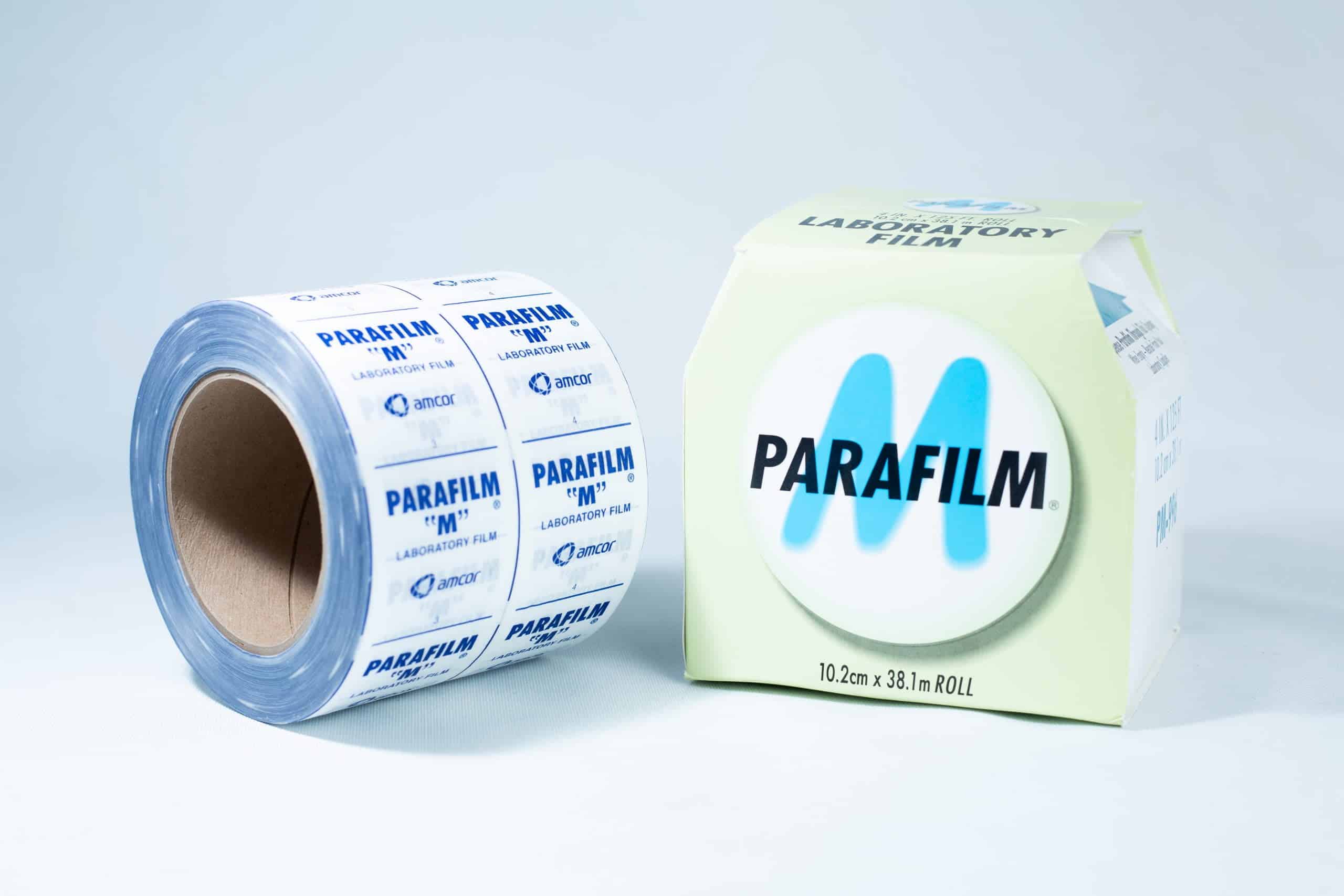 Parafilm Lab sealing film 2 A roll of Parafilm Lab sealing film is placed next to its packaging box on a white surface.
