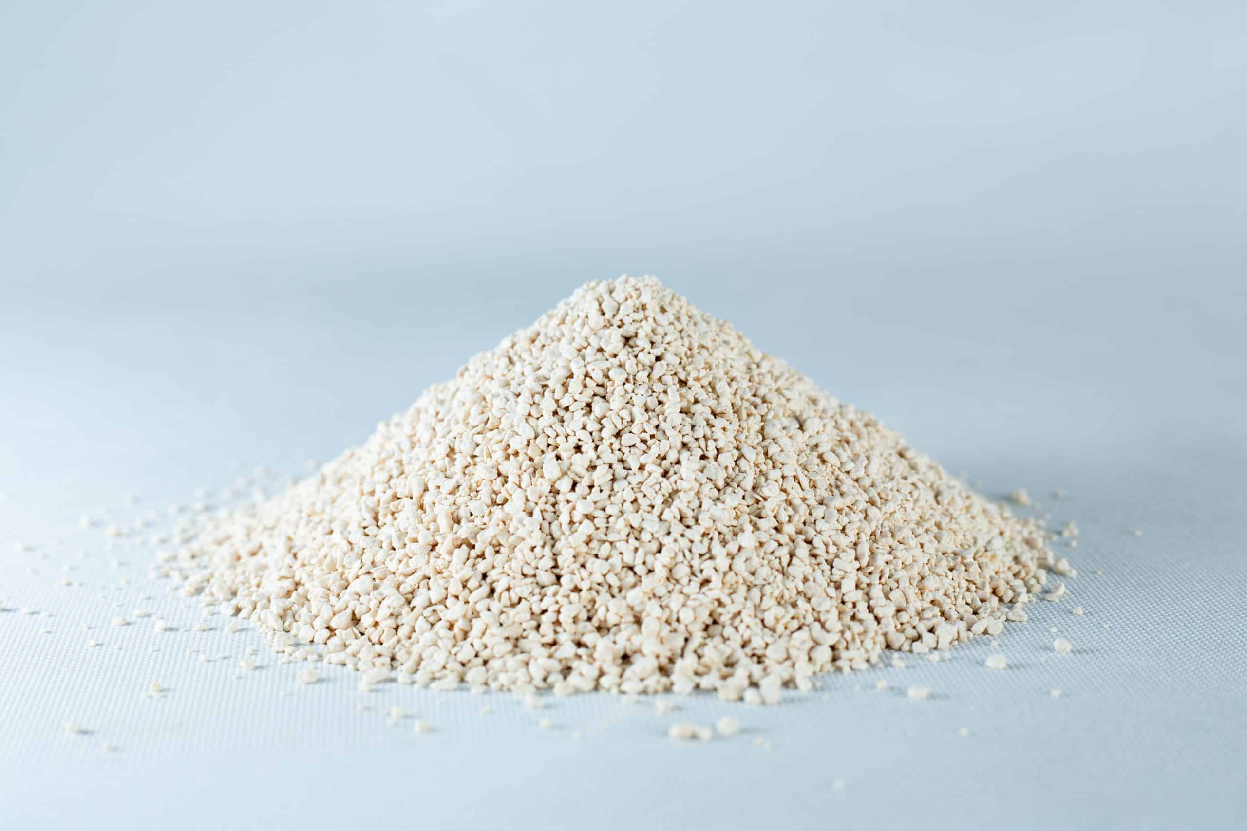 Potato Dextrose Agar powder -Lab Grade 2 A small mound of Natural Gypsum coarse grade mushroom supplement grain and substrate, featuring beige, granular powder, rests on a light grey surface.