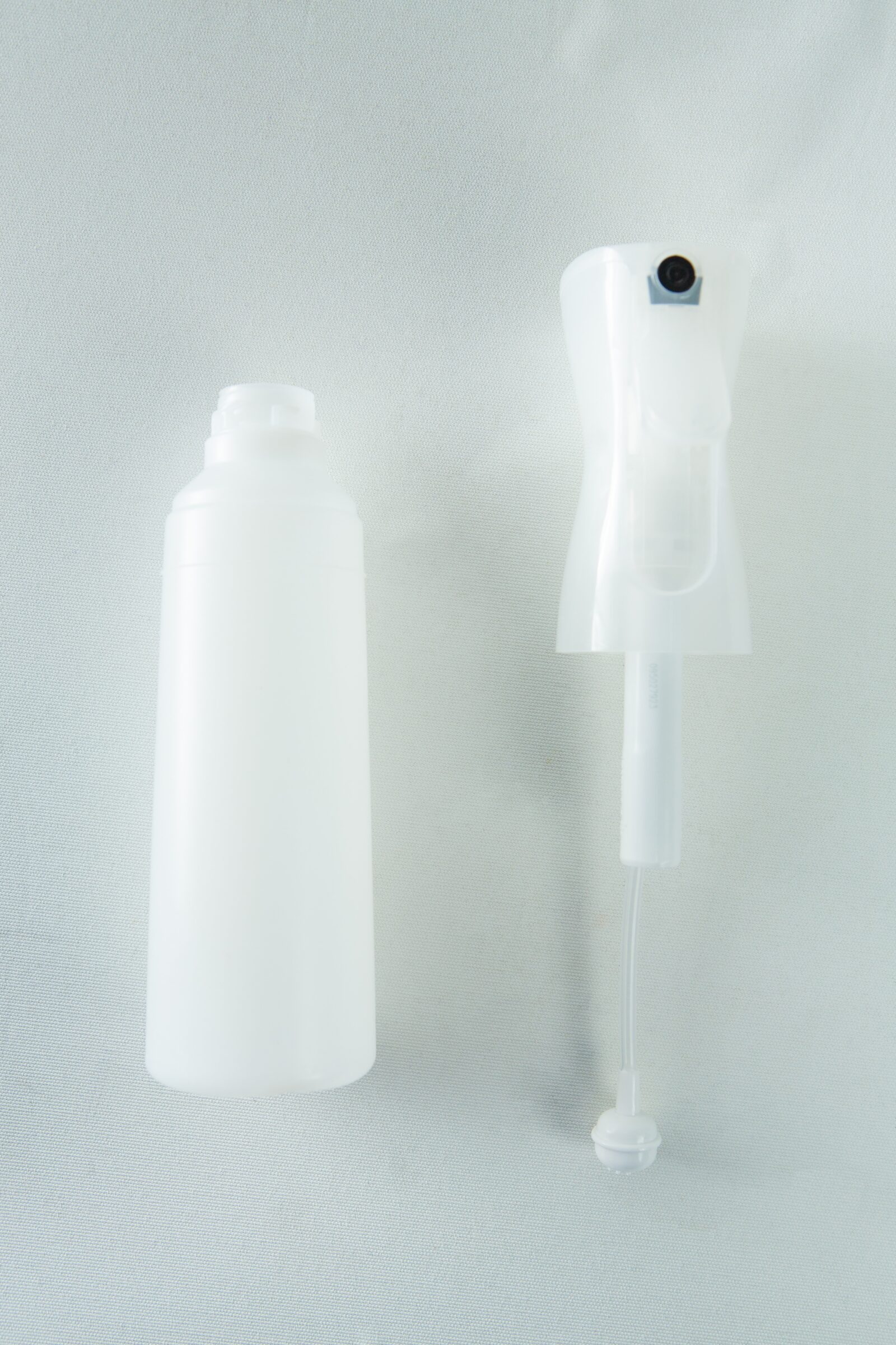 Spray Bottle Atomizer Mushroom fine mist 300ml 2 The Spray Bottle Atomiser Mushroom fine mist 300ml and a white plastic spray bottle with a trigger are set against a light background.