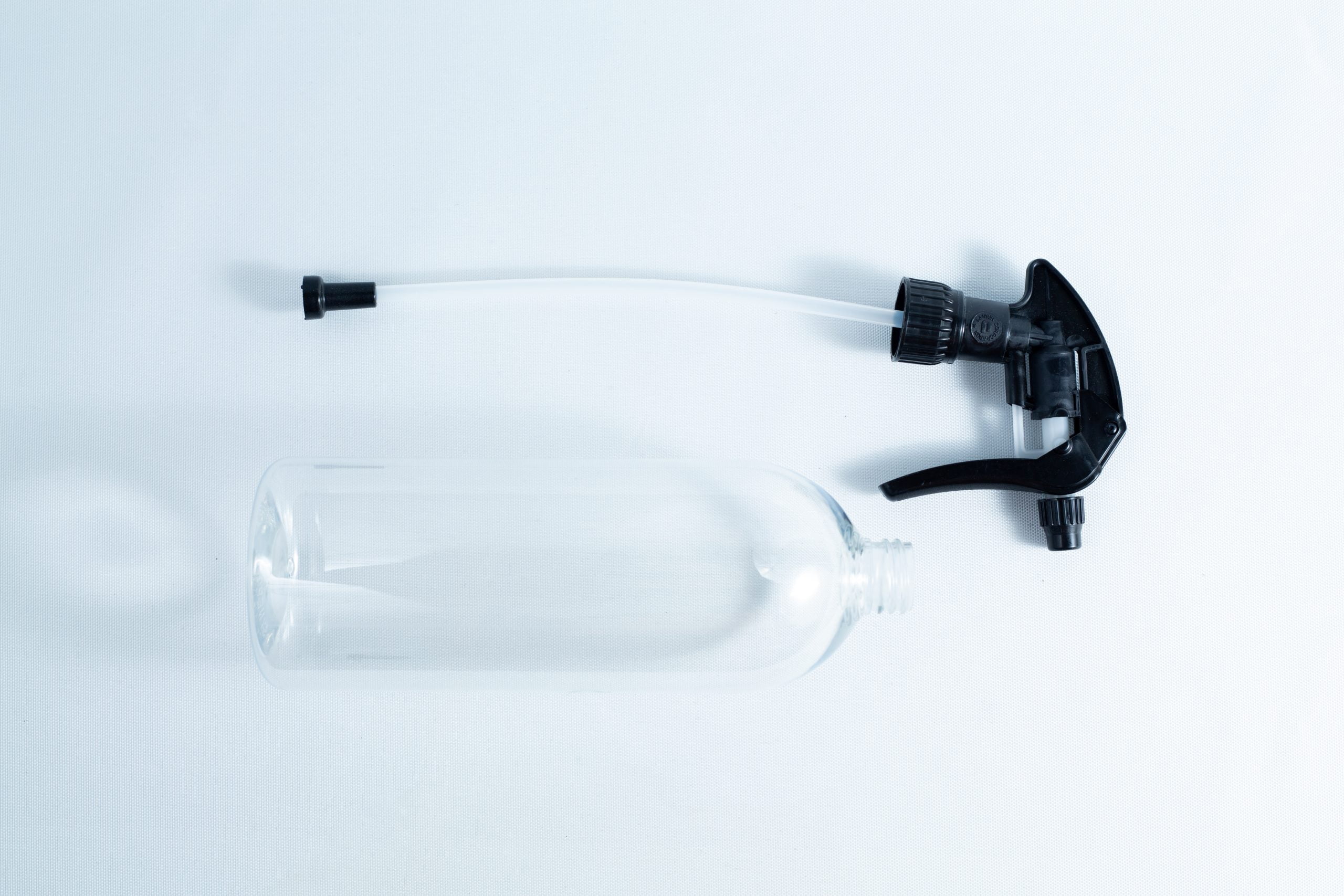 Spray bottle Chemical resistant 1 Liter Heavy Duty 3 The Spray bottle Chemical resistant 1 Litre Heavy Duty, with a detached black nozzle, rests on a white surface—an ideal choice for safely handling various chemical solutions.