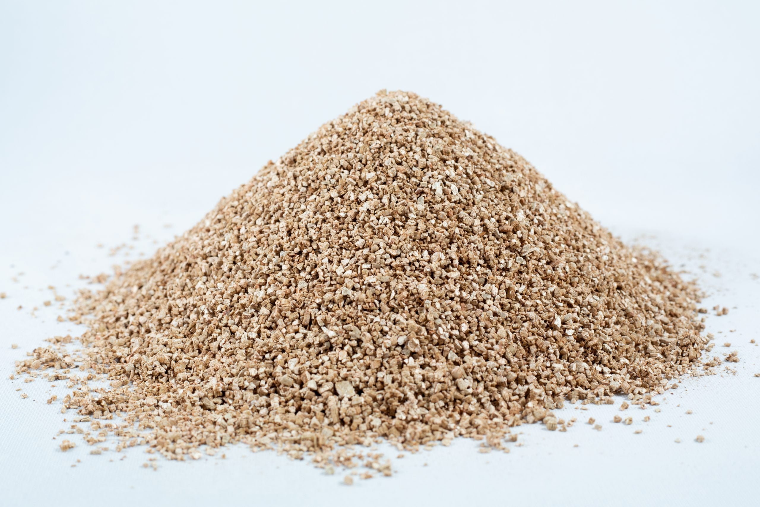 Vermiculite, Grade 2 , fine, mycology 1 A mound of vermiculite, grade 2, fine, mycology rests on a white surface.