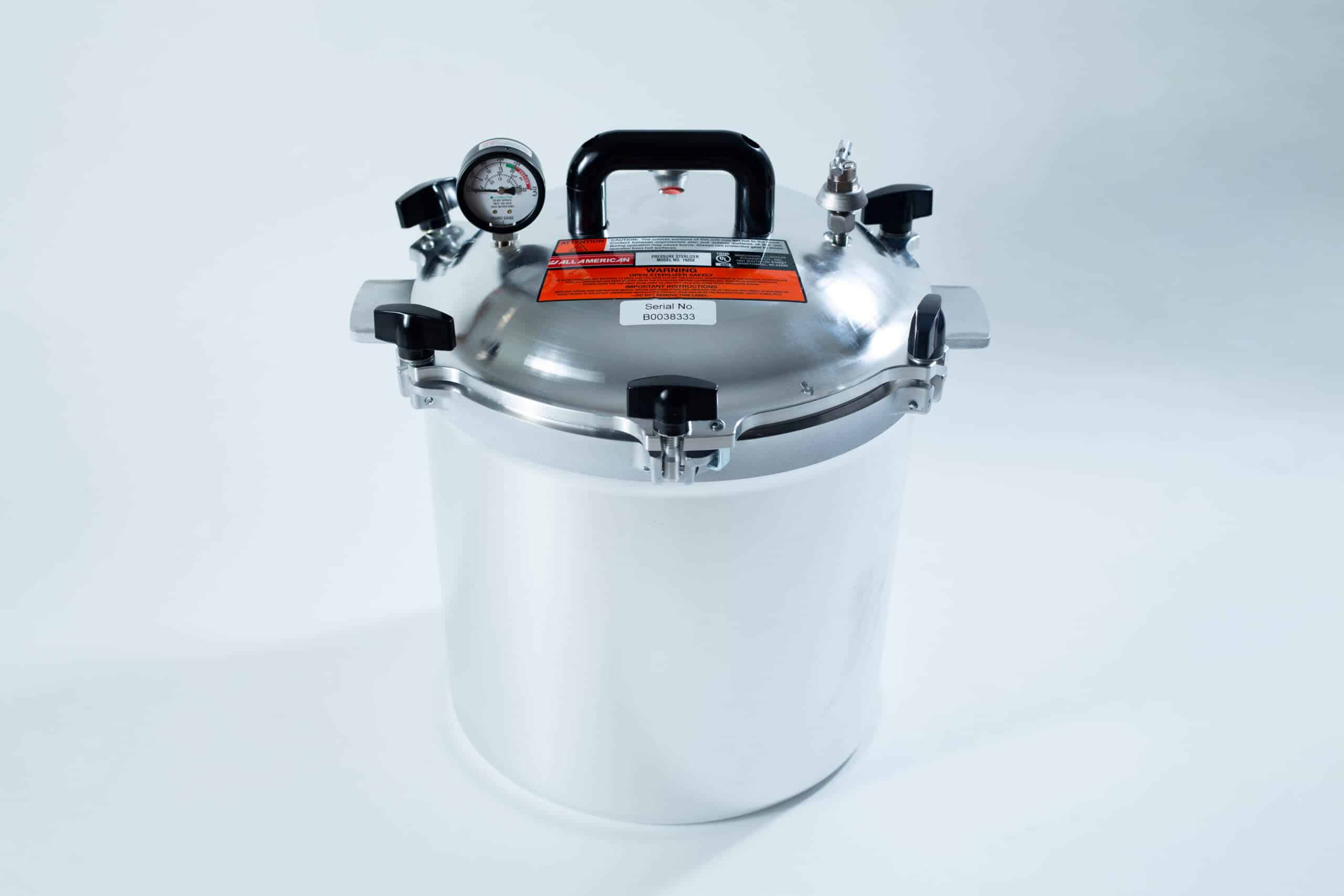 1925x All-American Sterilizer (Autoclave) 25 quart/ 24 Liter 1 A stainless steel pressure cooker with a gauge, handle, and safety valves on a white background.