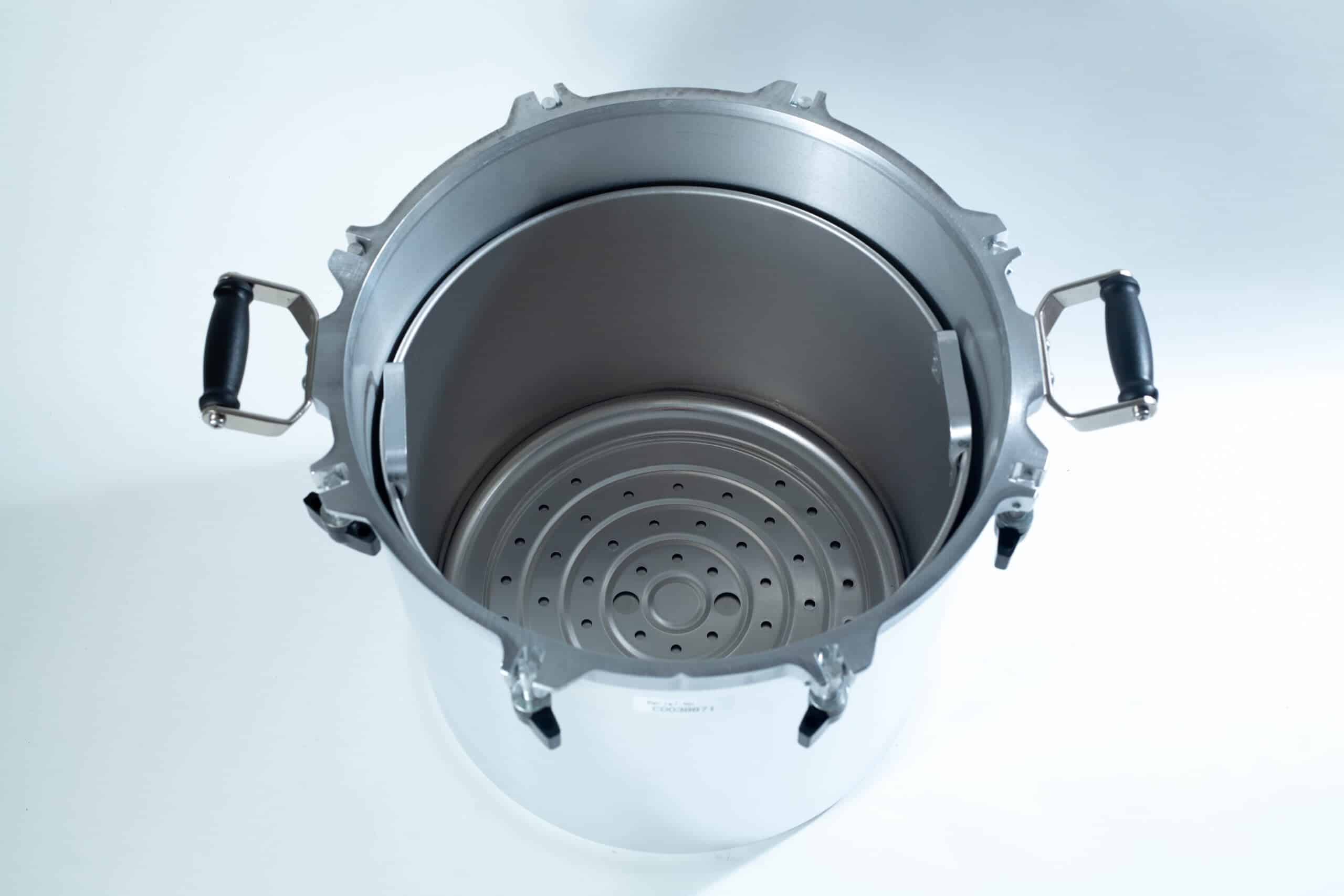 1941x All-American Sterilizer (Autoclave) 41 quart/ 39 liters. 4 Top view of a large stainless steel pressure cooker with black handles and a perforated metal rack inside.