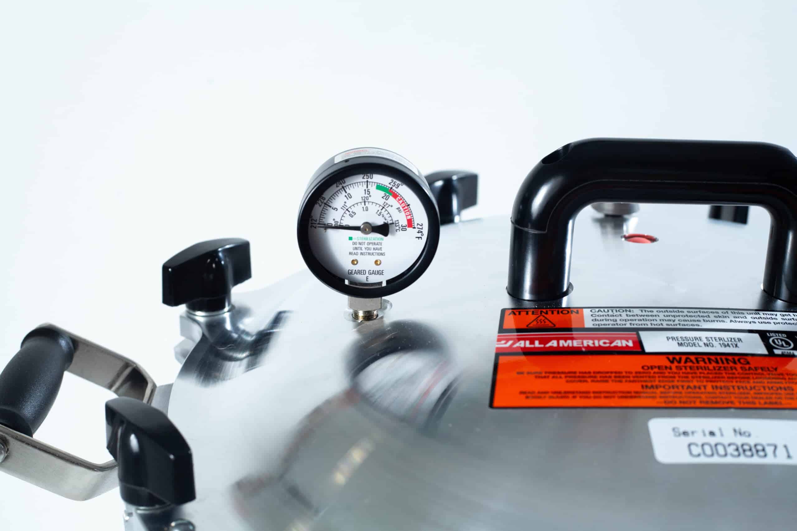 1941x All-American Sterilizer (Autoclave) 41 quart/ 39 liters. 6 Close-up of the All American Wingnut pressure canner lid featuring a pressure gauge, handles, and warning labels.