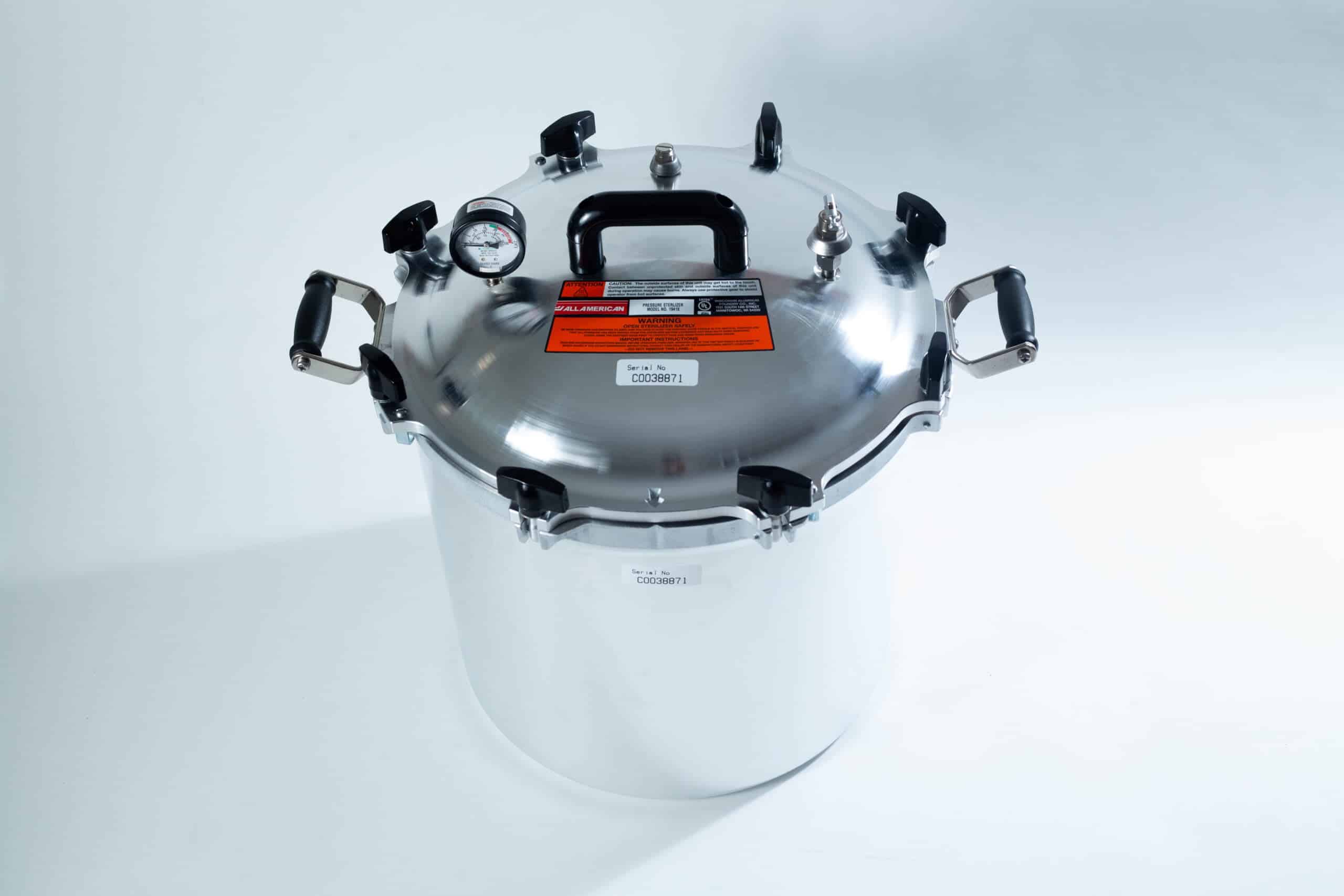 1941x All-American Sterilizer (Autoclave) 41 quart/ 39 liters. 1 A large stainless steel pressure cooker with a black handle and pressure gauge on a white background.