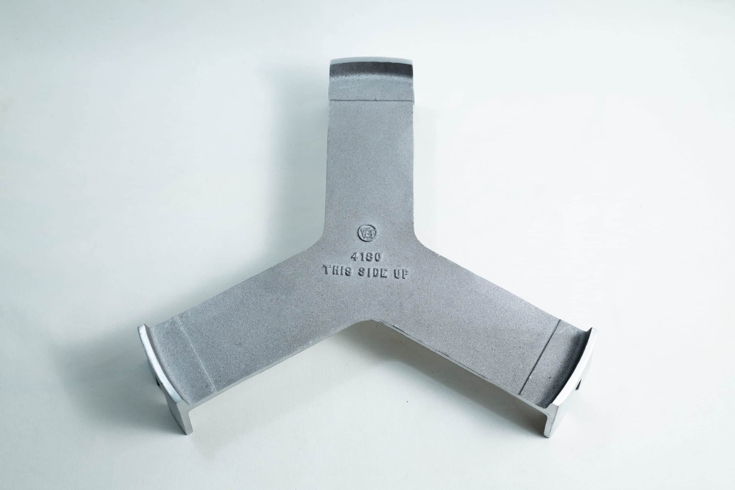 All American 4180 Support Base for 75X Sterilizers 1 Grey metal Y-shaped object with THIS SIDE UP 4180 stamped in the centre, on a plain white background.