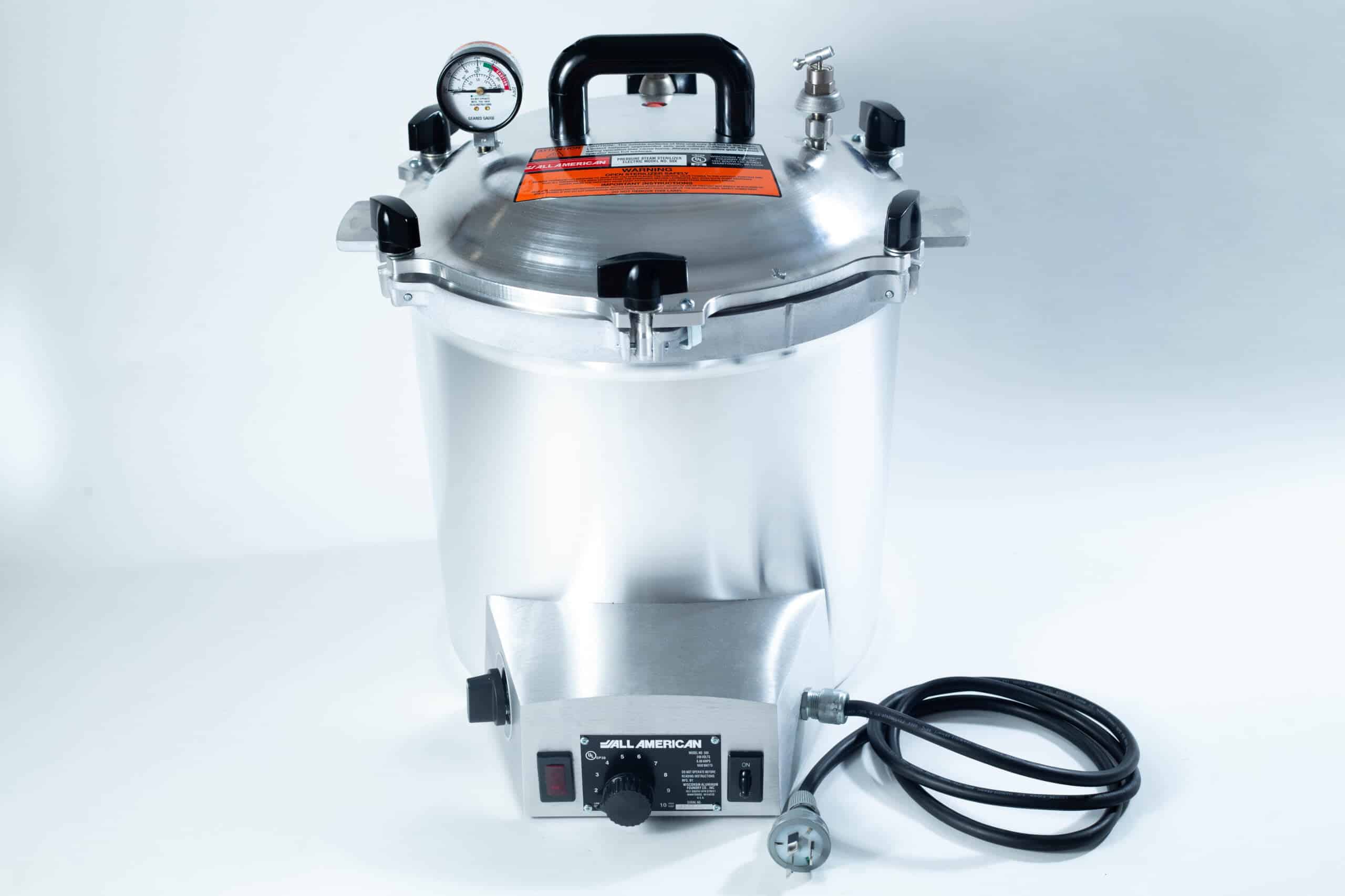 50x All American electric autoclave sterilizer 25 quart 1 Silver pressure cooker with gauge, handle, power lead, and control knob on a white background.