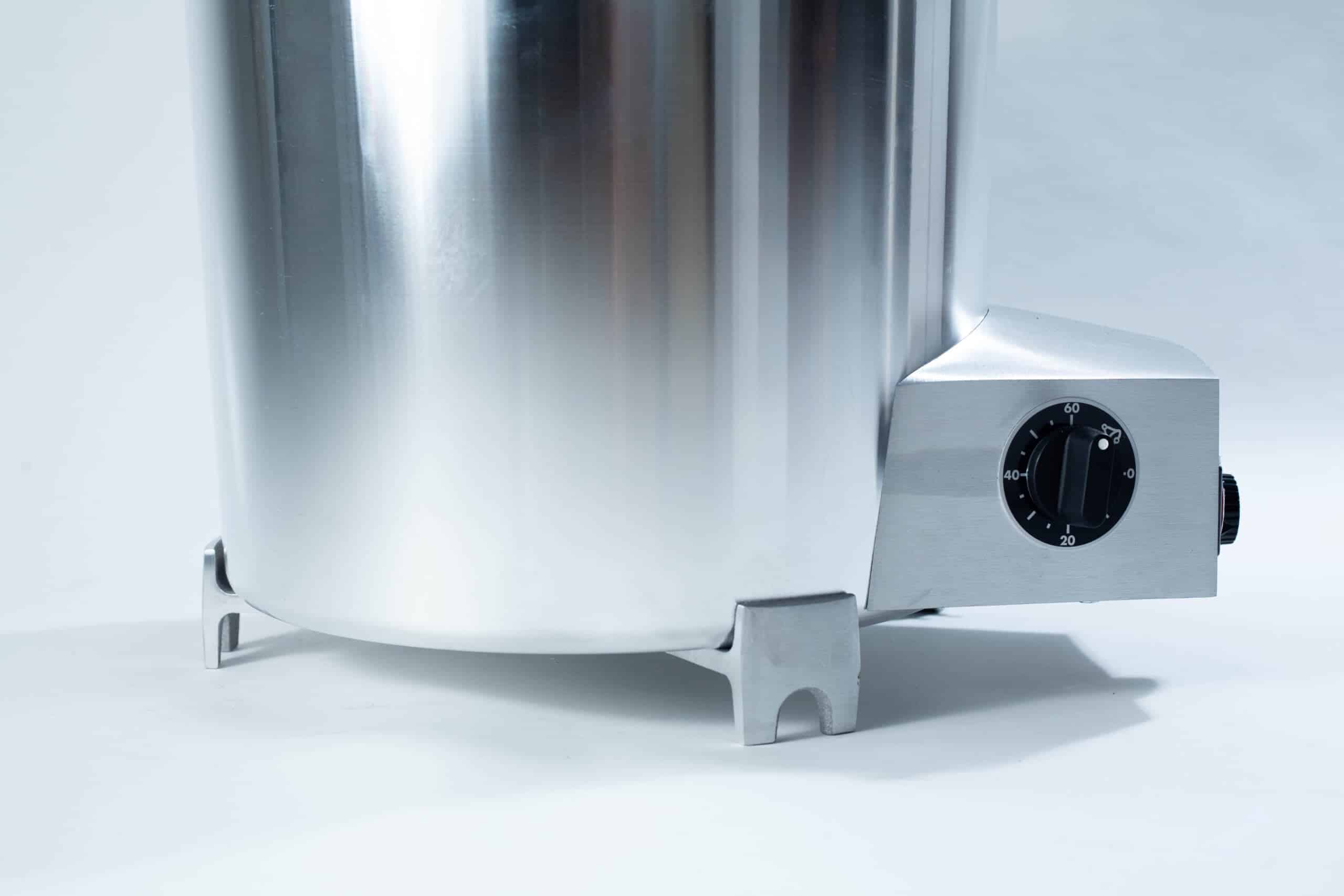 All American 2180 Support Base for 25X and 50X Sterilizers 4 Close-up of a stainless steel appliance with a black dial on a grey base, set against a light background.