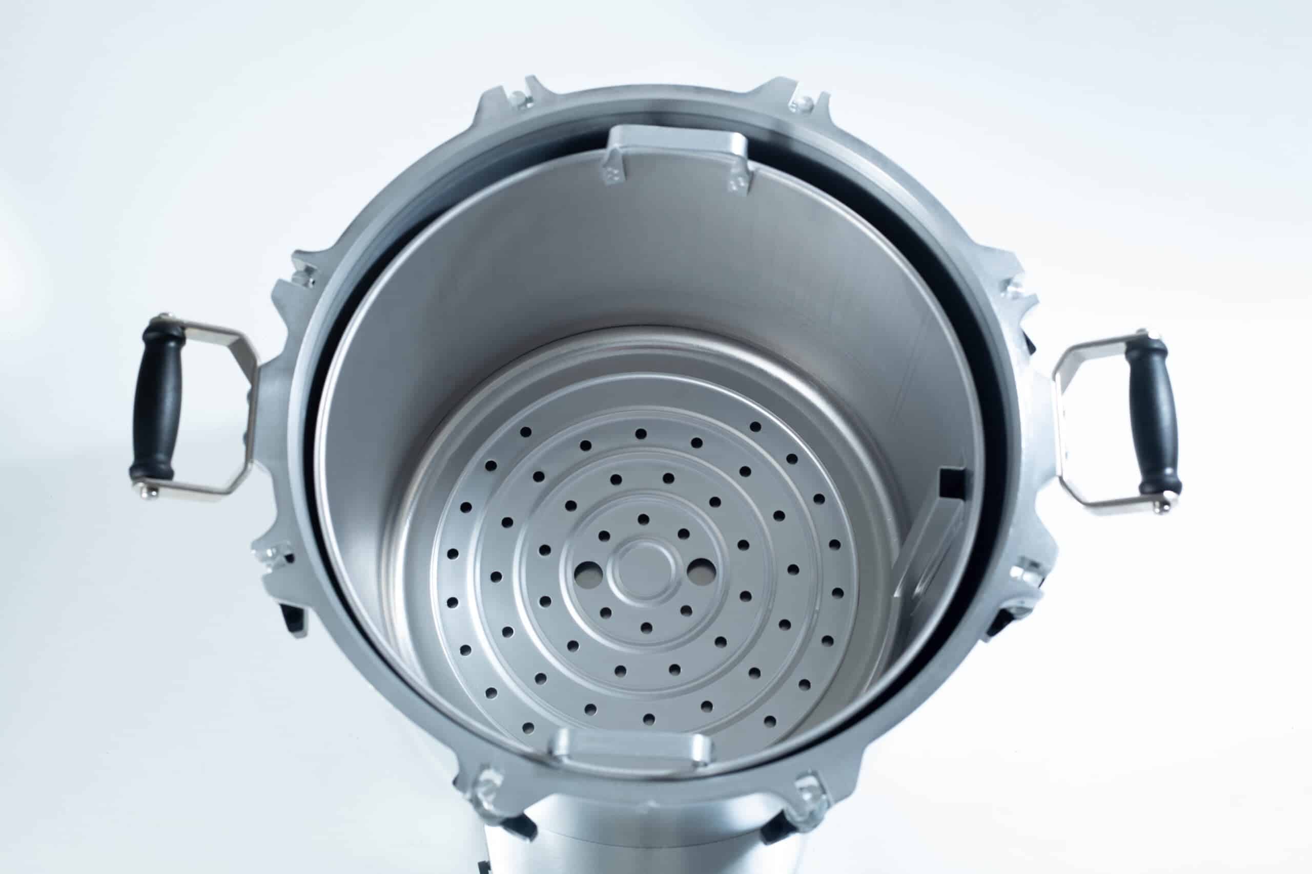 75x All American electric autoclave sterilizer 41 quart 5 Top view of an empty stainless steel pressure cooker with black handles and a perforated steamer insert.