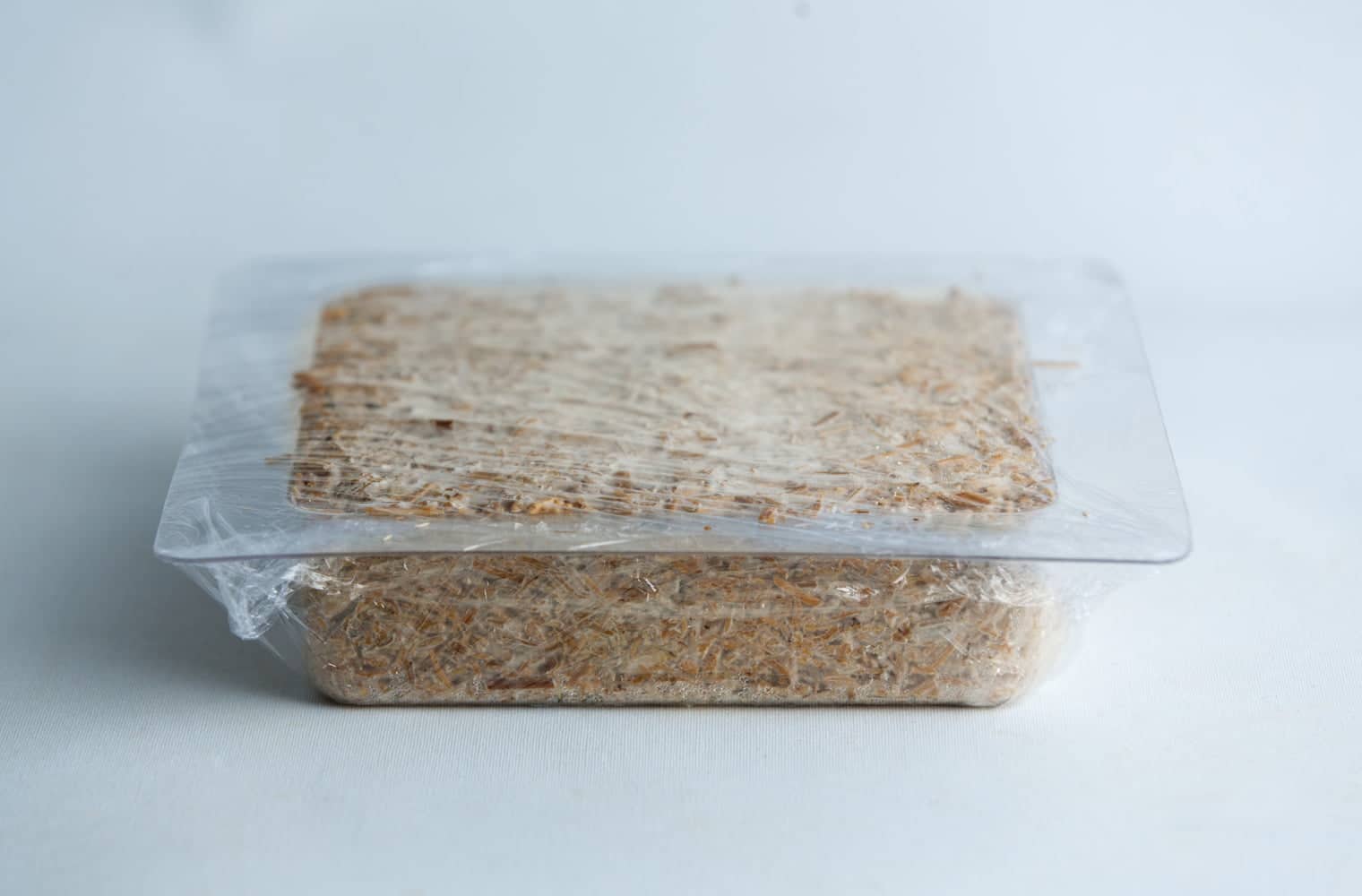 Mycelium Mold Growth form - Paver (Reusable) 8 A rectangular block of food wrapped in plastic on a white surface.