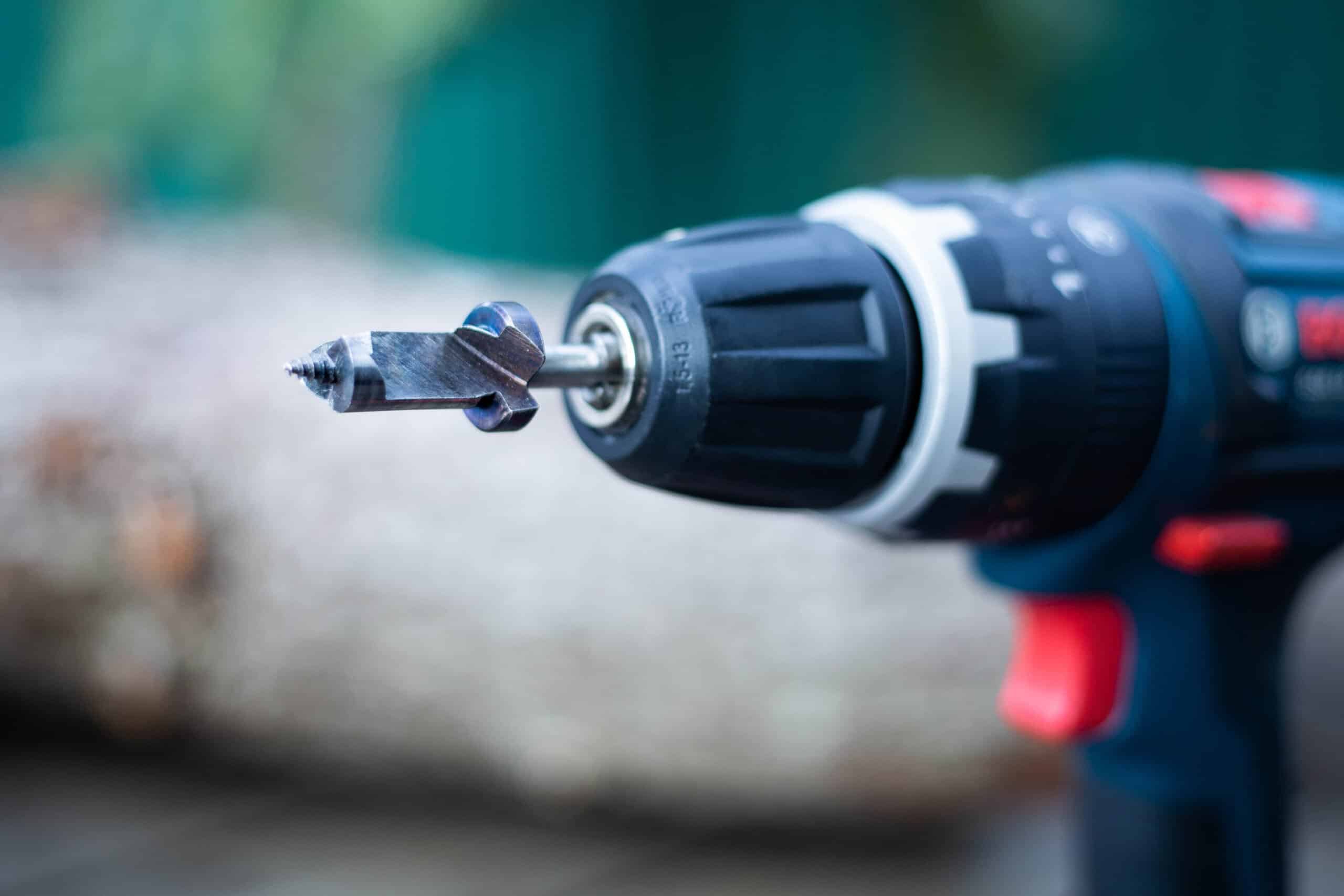12.5 mm Sawdust Inoculation Drill Bit With Stopper, Hex Shank 3 Close-up of a power drill with a drill bit attached, shown in an outdoor setting.