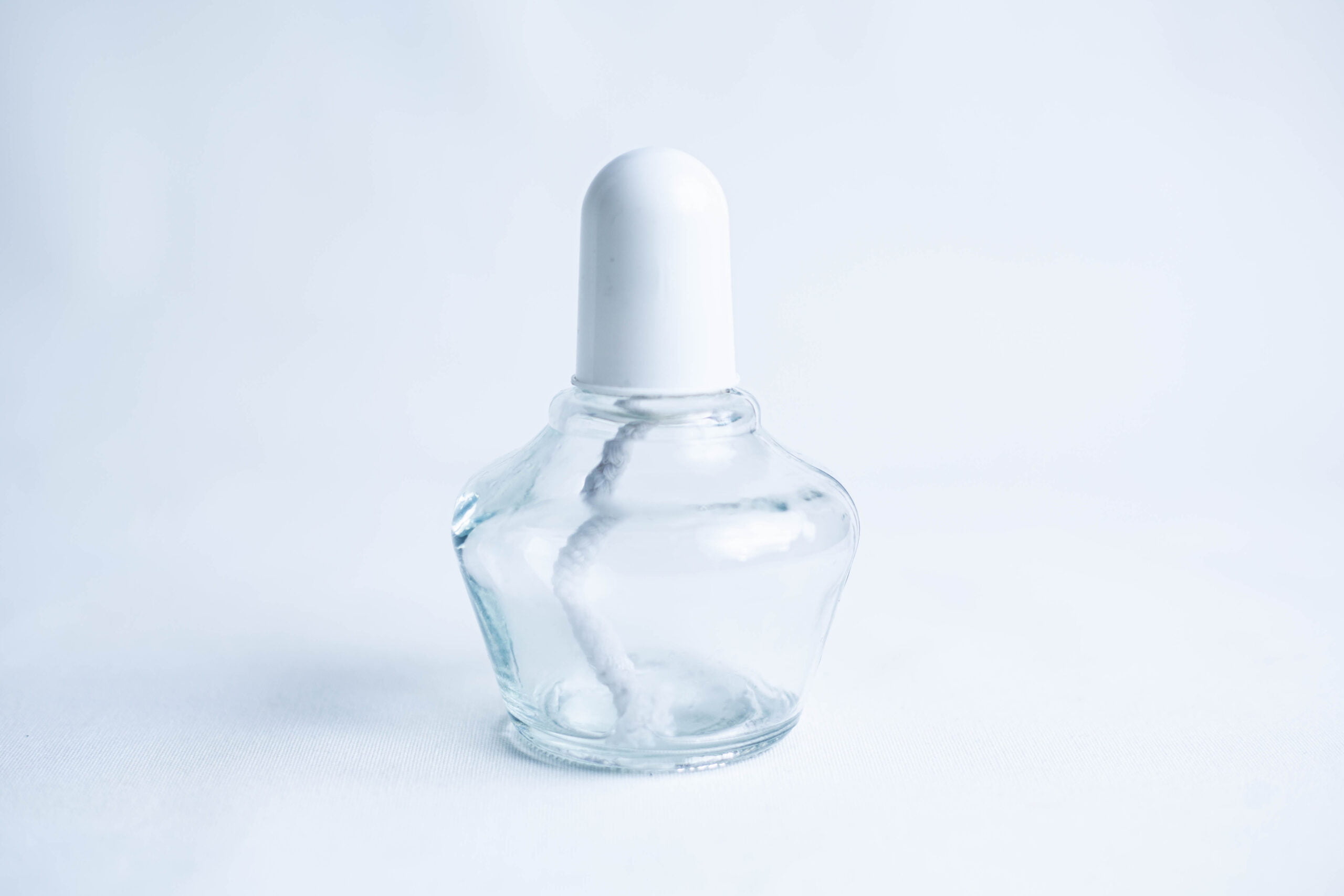 Lamp Spirit glass alcohol burner 150ml 3 Clear glass bottle with a white cap and a visible cotton bud inside, set against a light background.