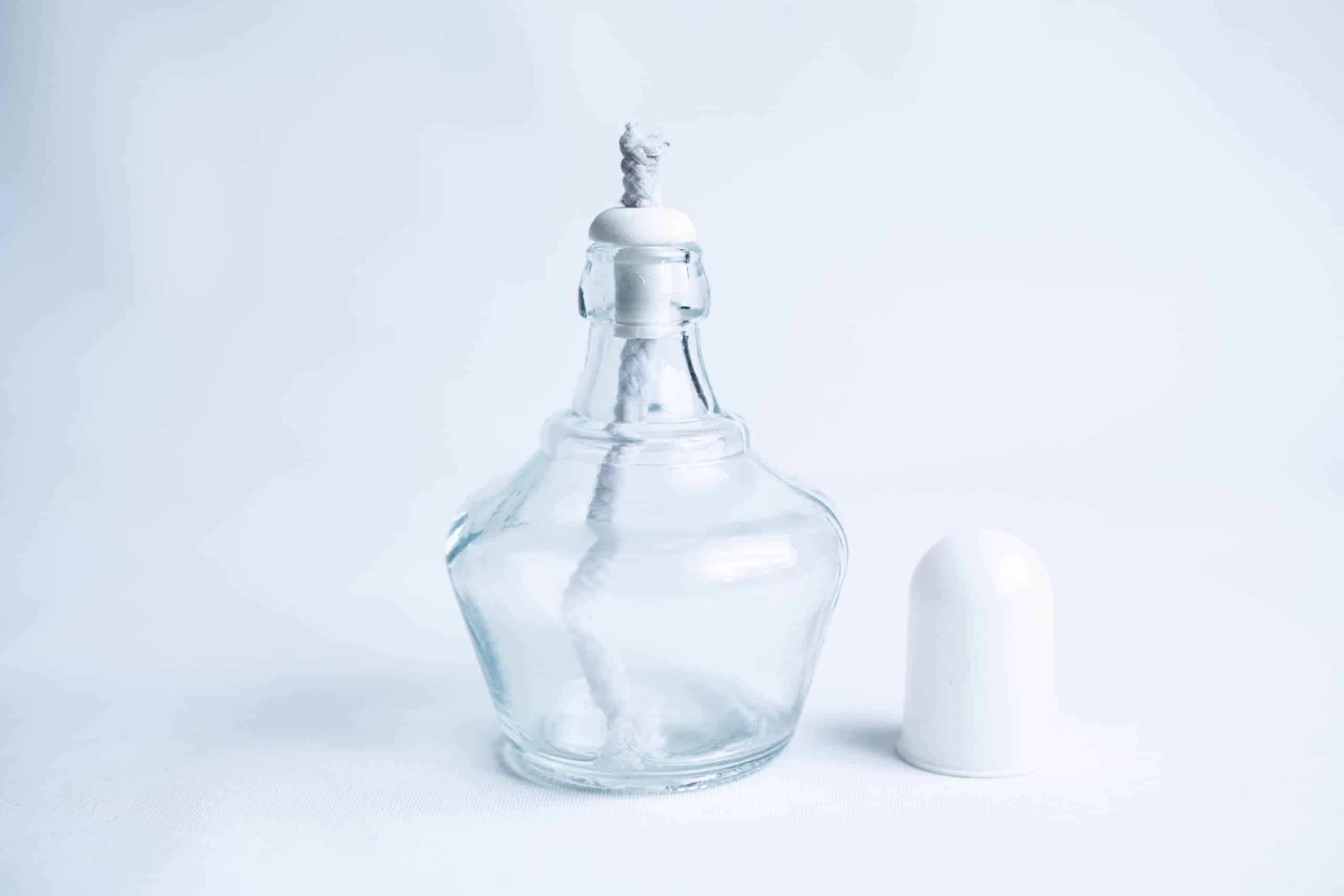 Lamp Spirit glass alcohol burner 150ml 2 Clear glass perfume bottle with a stopper and white cap placed beside it on a white background.