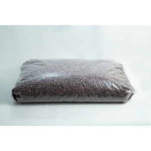 A sealed plastic bag filled with brown wood pellets on a plain white background.