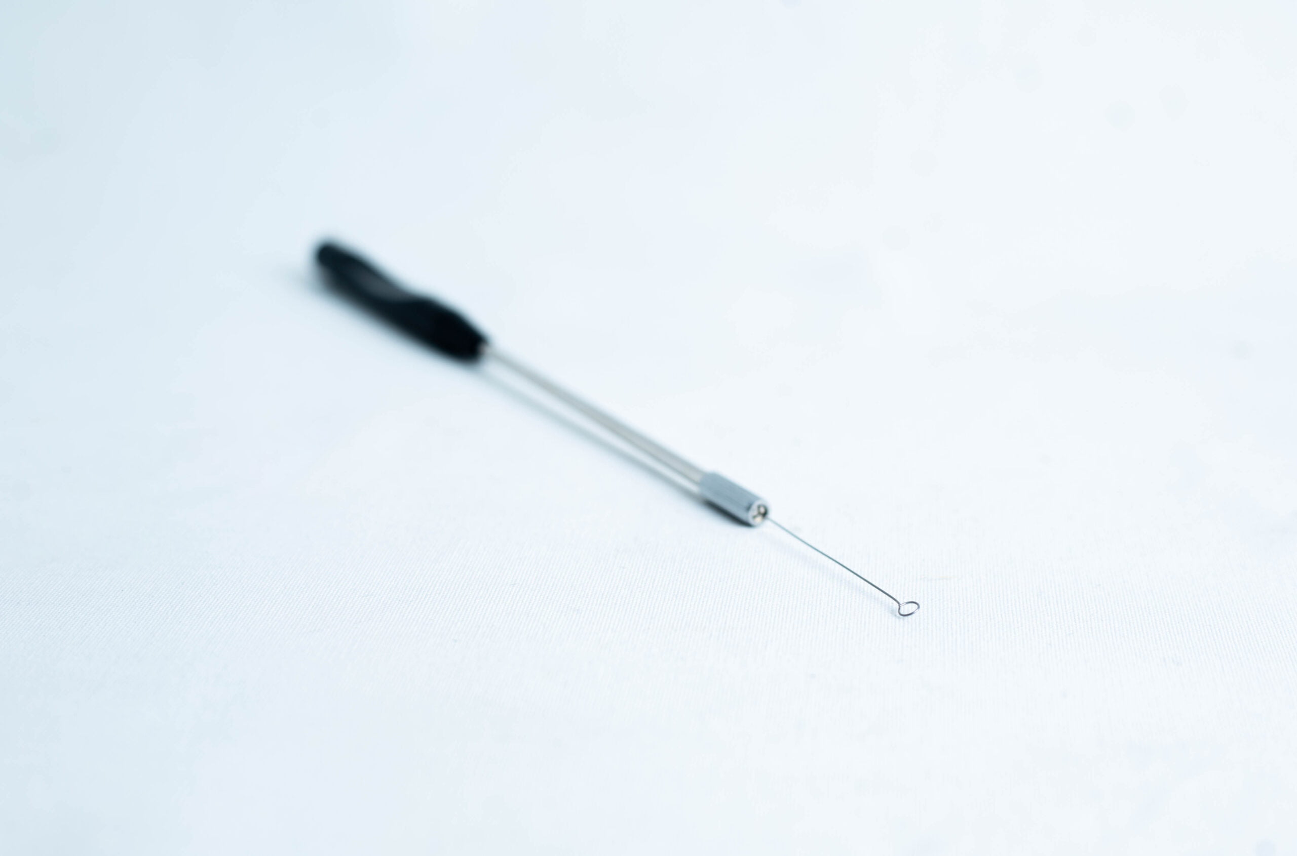 Inoculation Rod with Loops 3 A close-up of a metal blackhead remover tool on a white surface.
