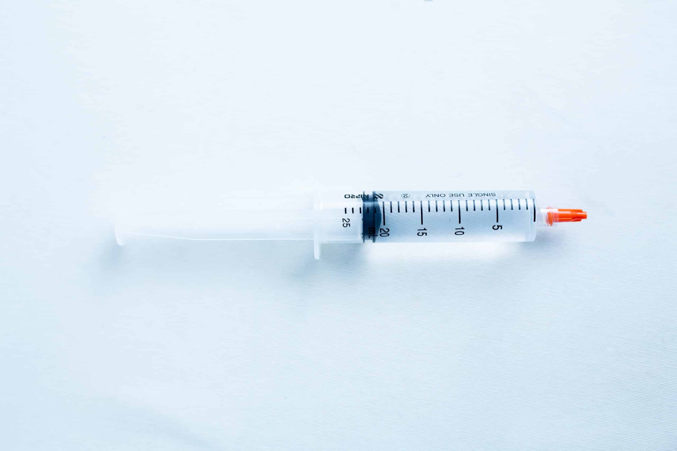 Antibacterial sterile water or sterile water to make spore syringe 1 A plastic syringe with a red cap placed on a light blue surface.