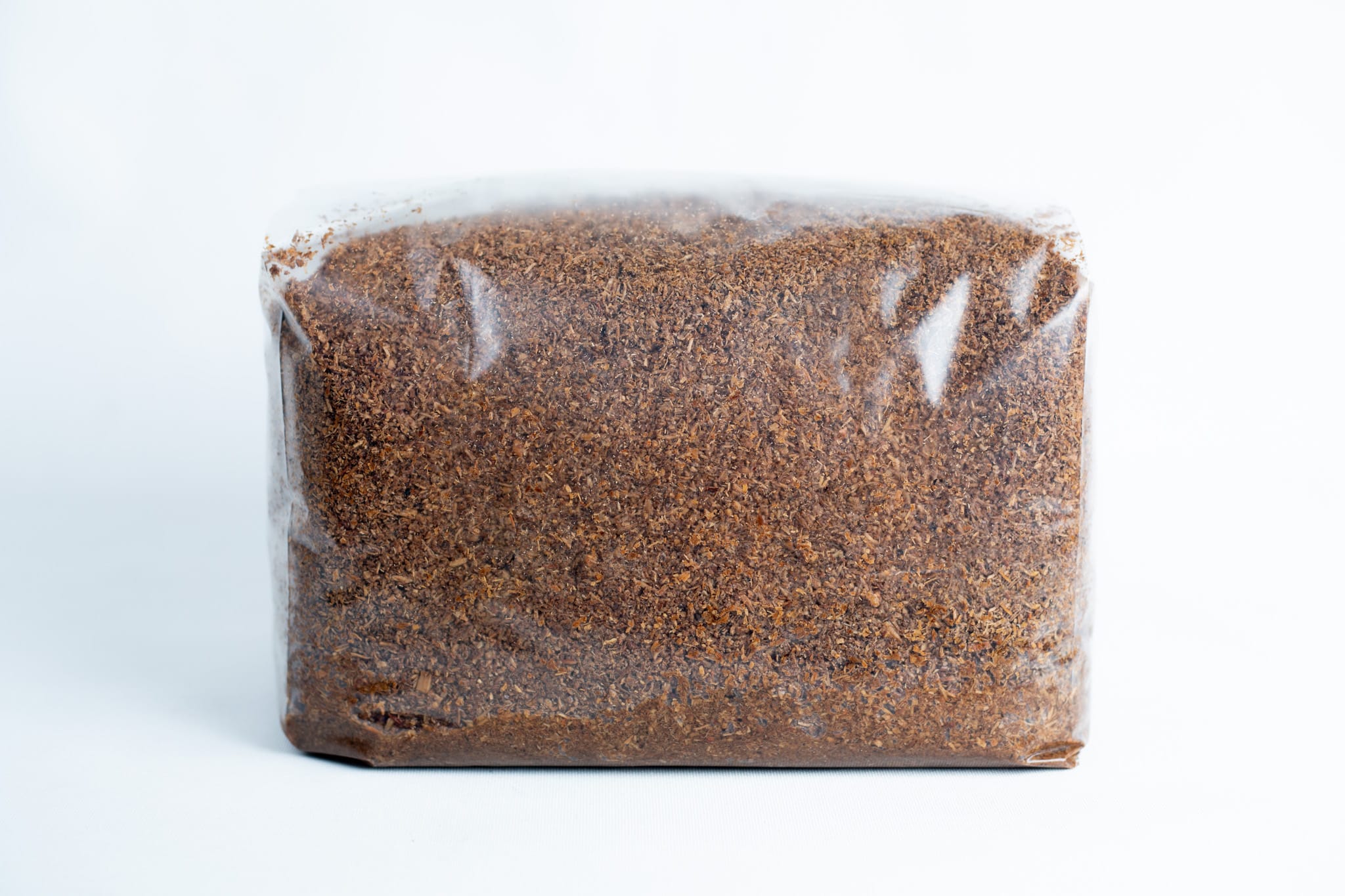 Hardwood Sawdust and Bran Mushroom Substrate for wood loving mushrooms 1 A clear plastic bag contains finely ground brown Masters Mix Mushroom Substrate, made from sawdust and soya pellets.
