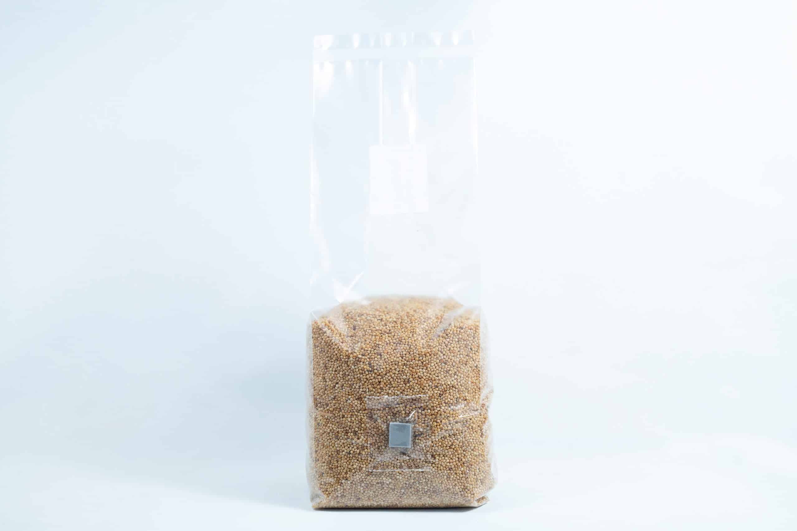 Millet pre sterilized mushroom grains w/inj port and digital instructions 1 A clear plastic bag of Millet Pre-Sterilised Mushroom Grains with injection port and digital instructions, sealed at the top, shown on a white background.