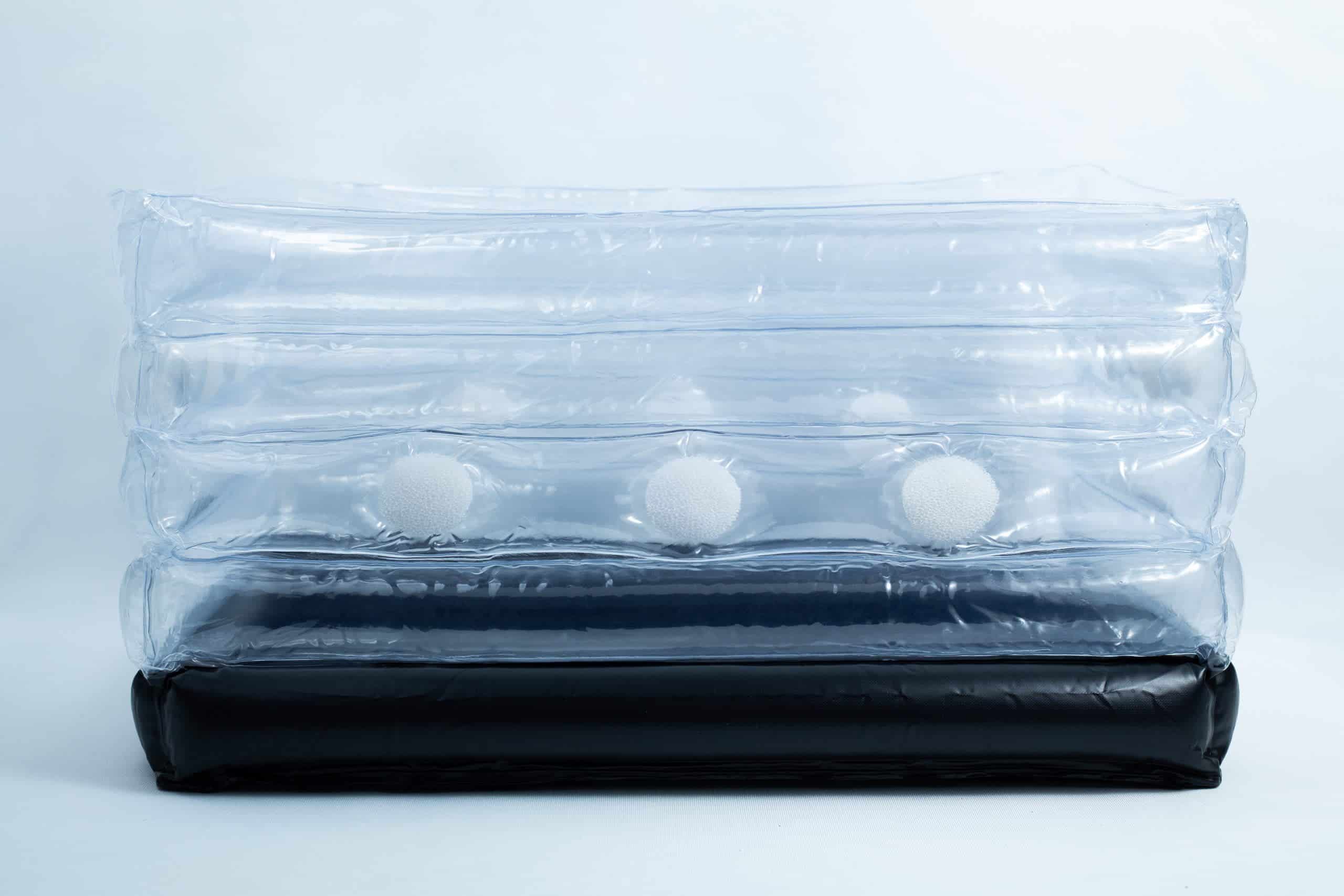 Inflatable monotub kit for Growing mushrooms- Boomer Shroomer V 2.0 4 Clear inflatable plastic packaging with white foam balls inside and a black base, set against a plain background.