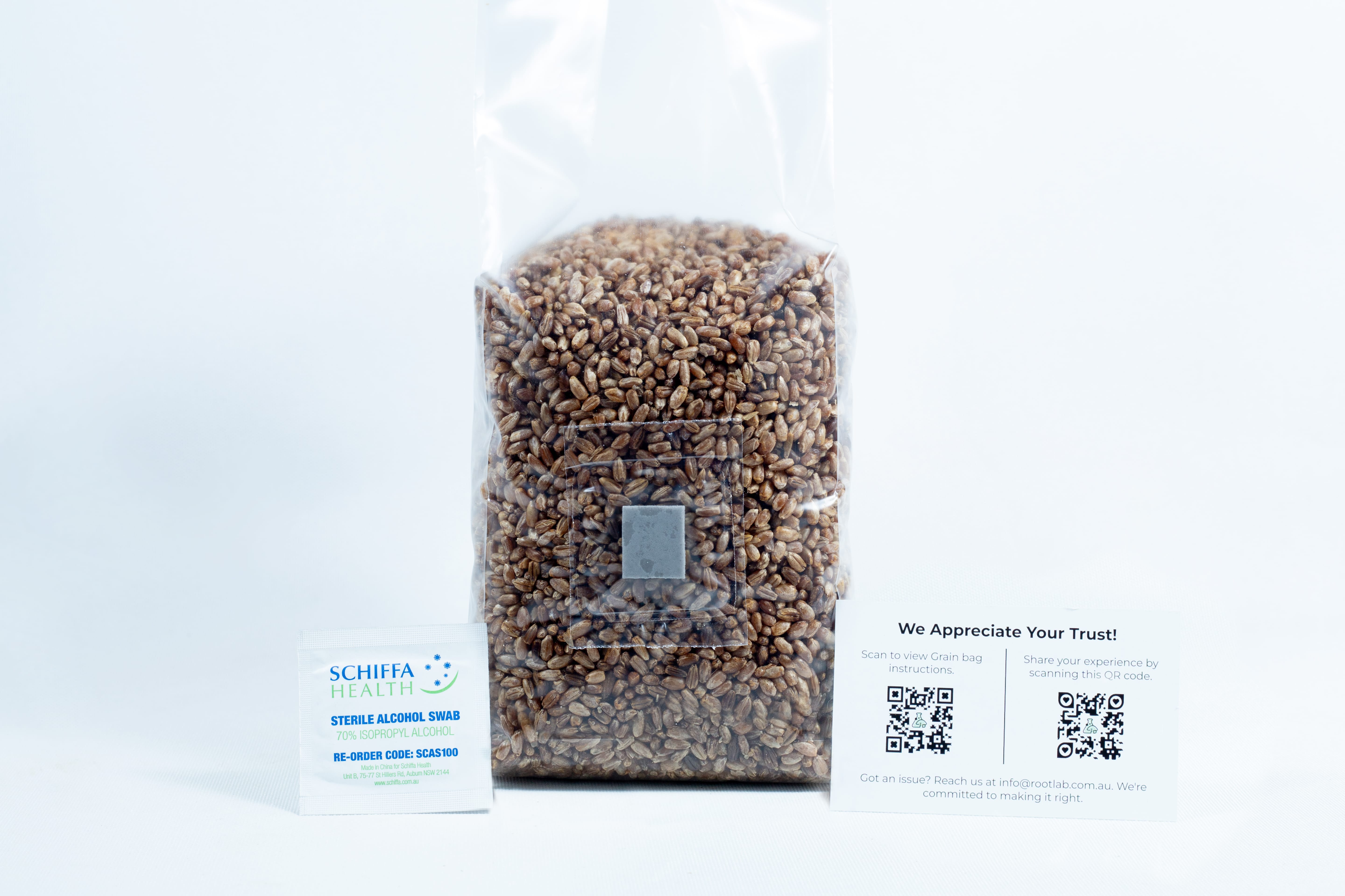 Monotub Mushroom Growing Kit-Premium 7 A sealed bag of grains for the Monotub Mushroom Growing Kit–Premium, accompanied by a packet and a card displaying QR codes, is placed beside it on a white background.