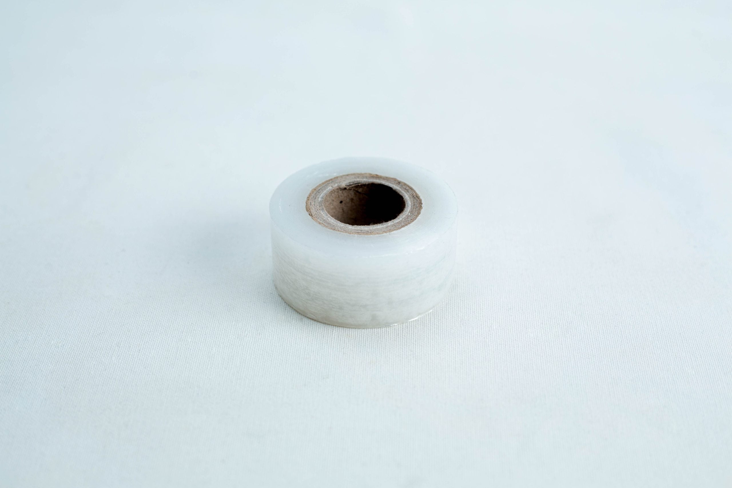 Grafting Tape to seal agar plates or for plant grafting 3 A single roll of "Grafting Tape to seal agar plates or for plant grafting" rests on a plain white surface, perfect for sealing agar plates or use in plant grafting.